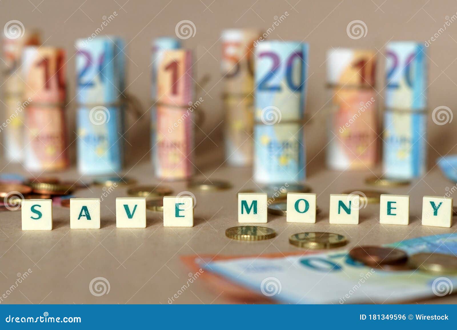 cubes spelling save money on the table with spanish dinero bills and coins