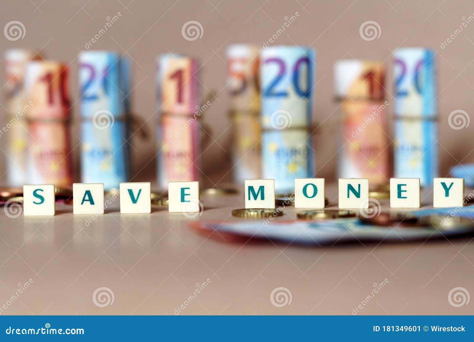 cubes spelling save money on the table with spanish dinero bills and coins