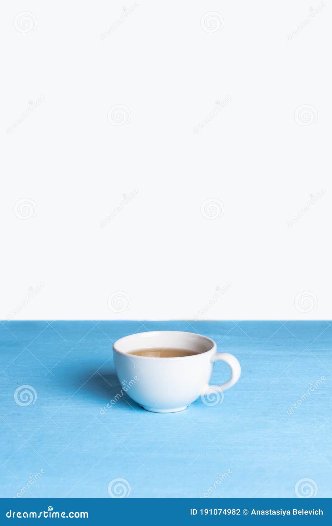 White Cup of Tea on a Bright Blue Background. Space for Text Stock