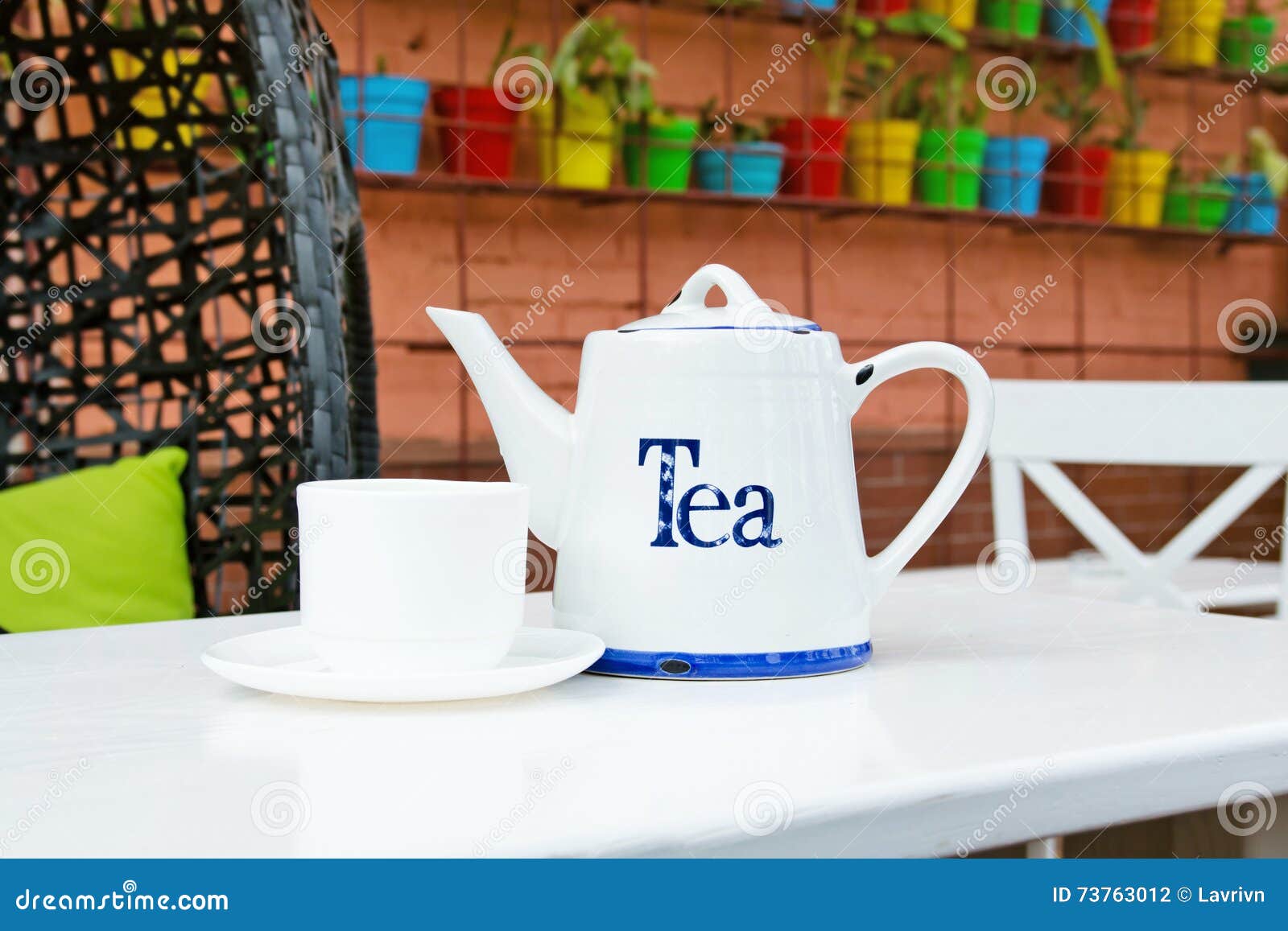 white cup and teapot tea in outdoor cafee