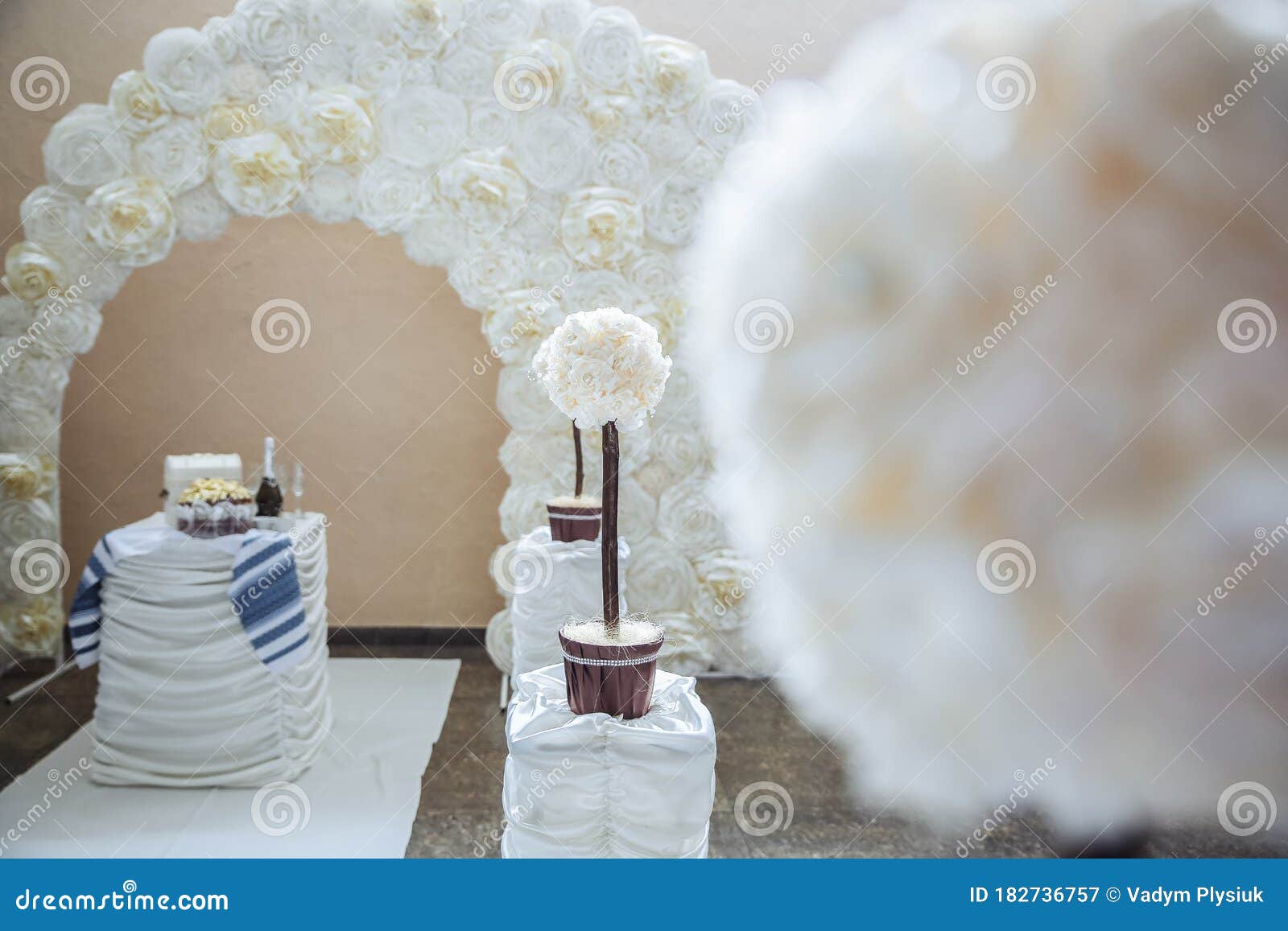 White Decorations at the Wedding. Arch and Table with Paper Flowers
