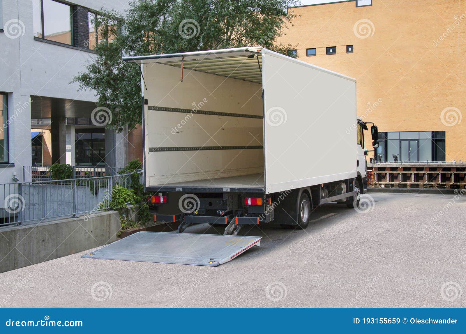 White Delivery Truck with Tailgate Open in Front of an Office Building