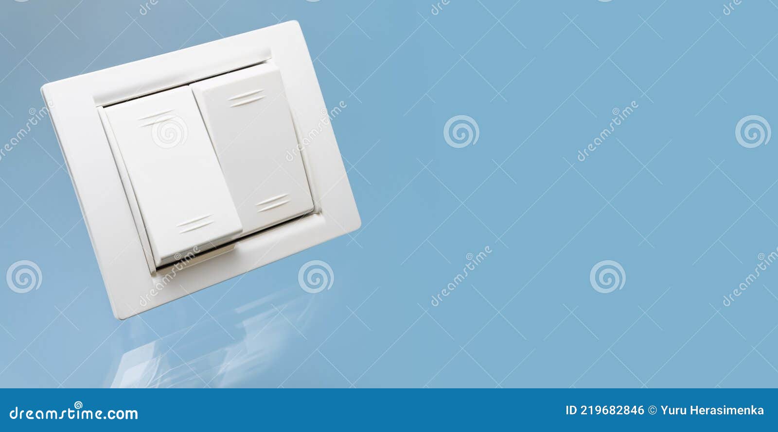 White Double Electrical Switch with Reflection on a Blue Background. Closeup. Electrical and