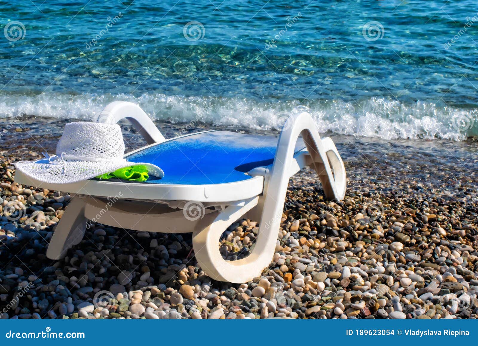 White, Empty, Plastic Deck Chair Under the Sun on the Beach. a