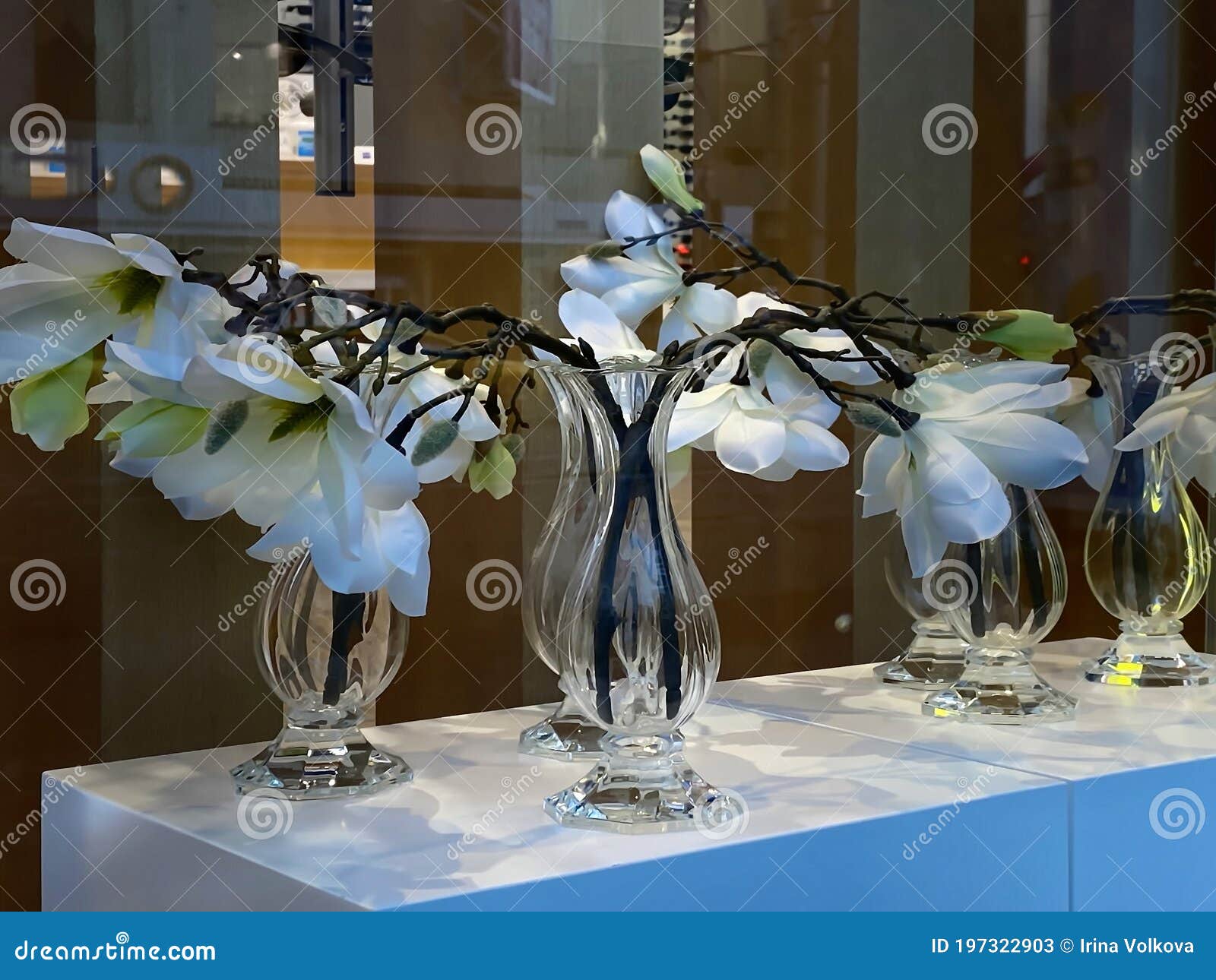 white exotic artificial flowers  in  vase on window top in street store window vitrine