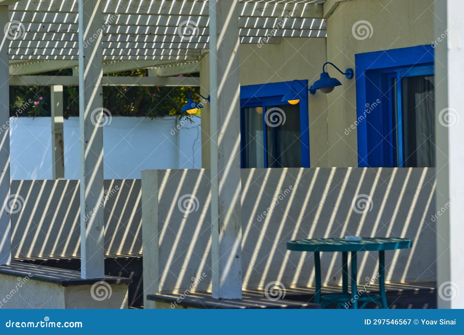 white faÃ§ades in light and shadow with blue doors nahsholim israel