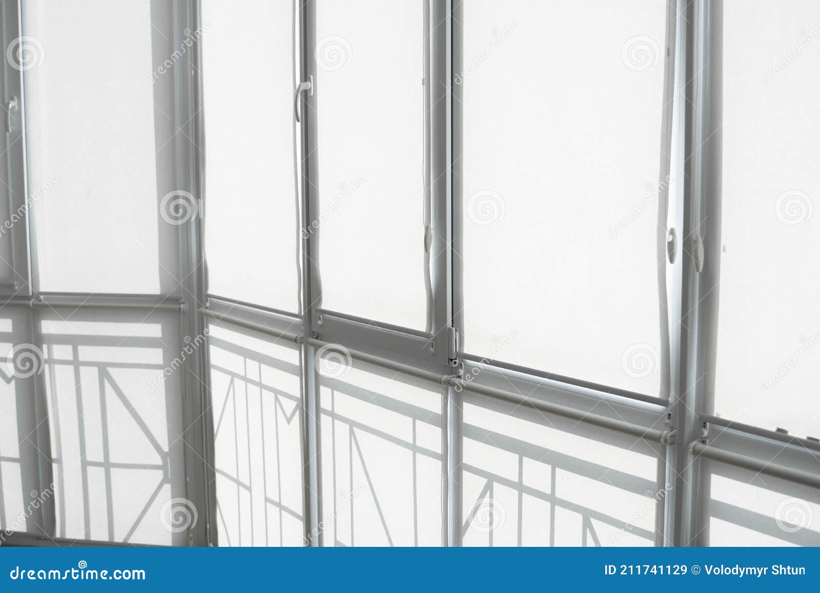 White Fabric Roller Blinds on the Plastic Window on a Balcony in the