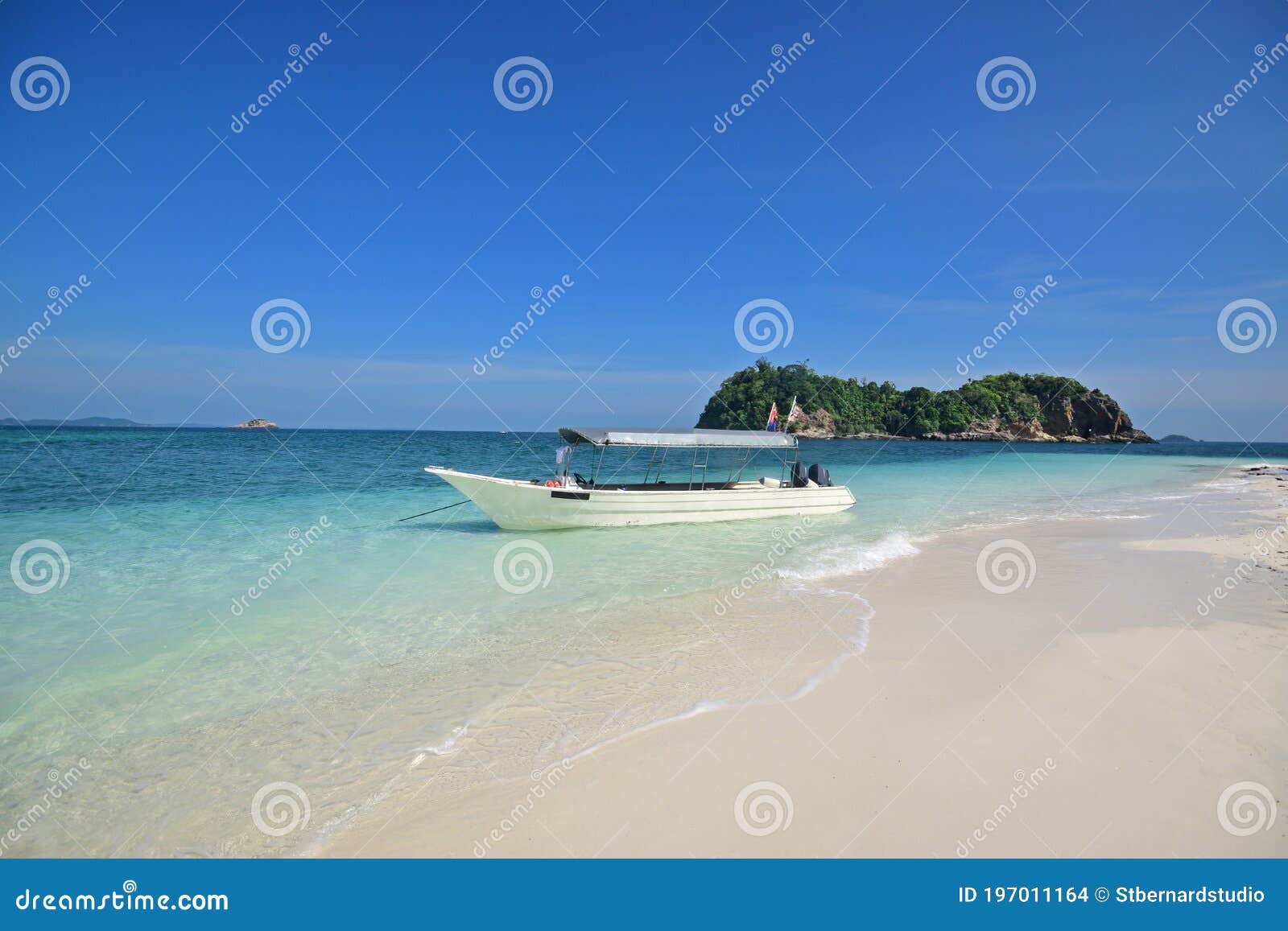 white fine sandy sand & shallow blue water with speed boat & cloudless sky at pulau lima besar island, johor, malaysia