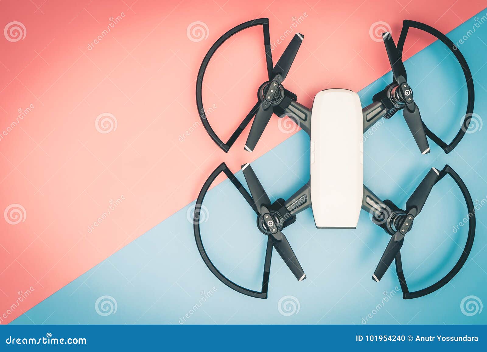 White Flying Gadget Toy Drone Top View on Blue and Pink Stock Photo