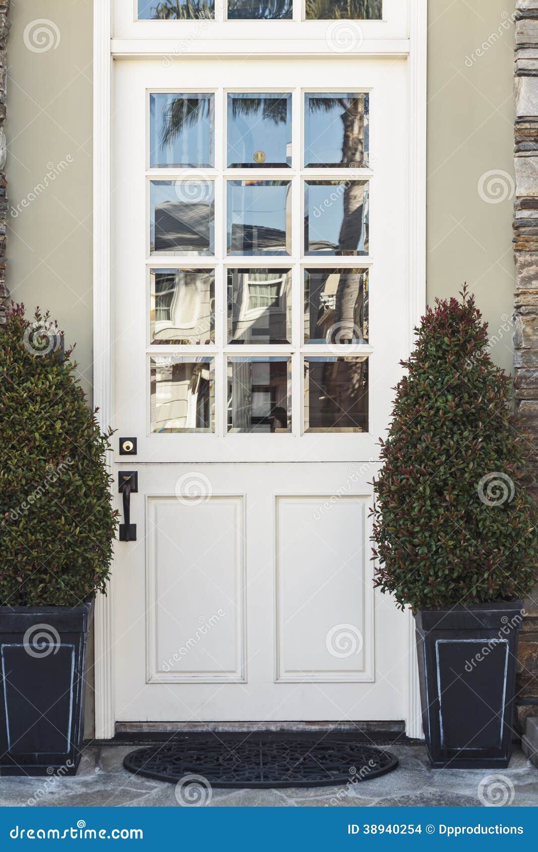 White Front Door To Modern Home Flanked By Plants Stock Photo