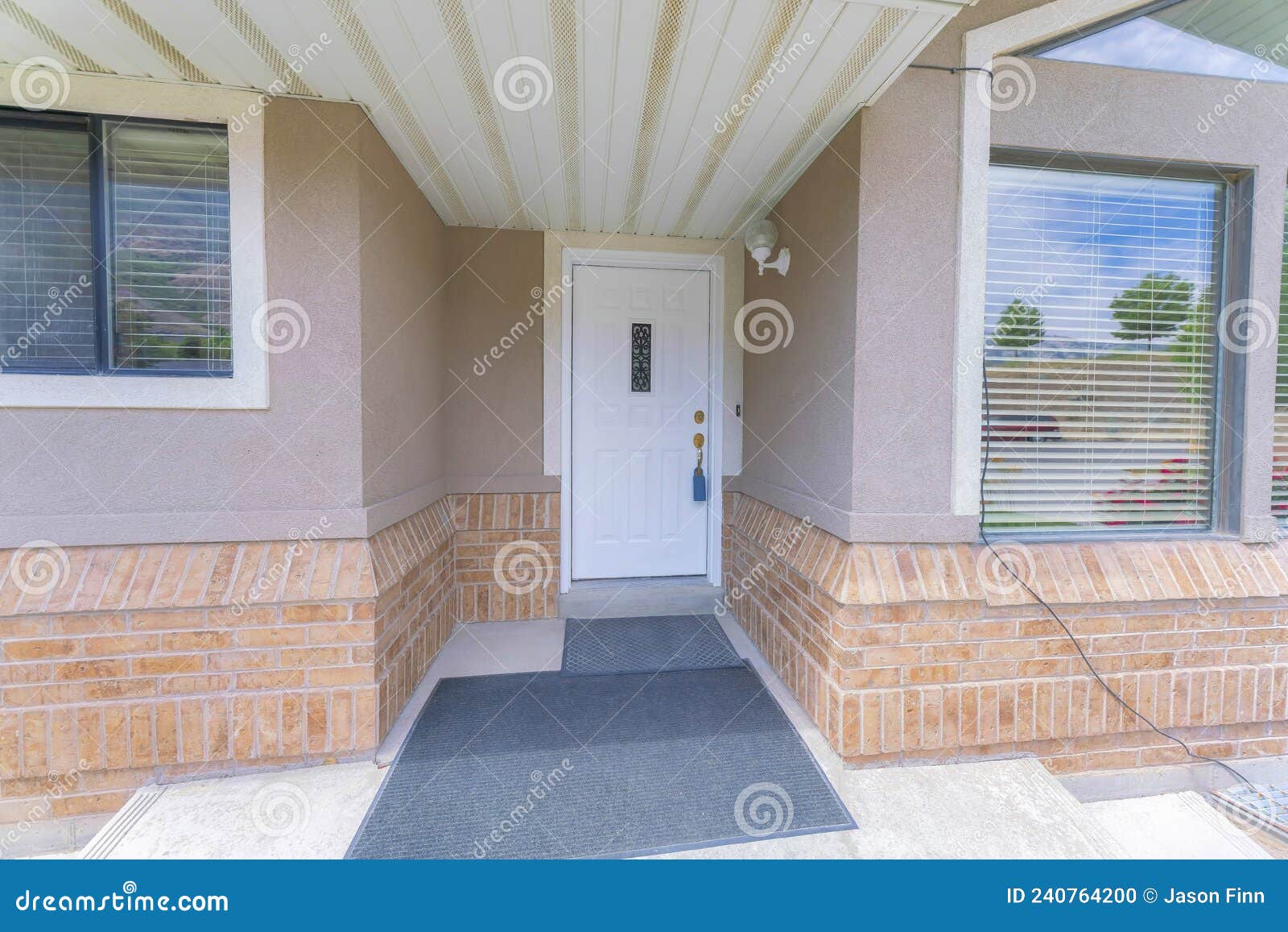 white front door with wrought iron panel and lockbox