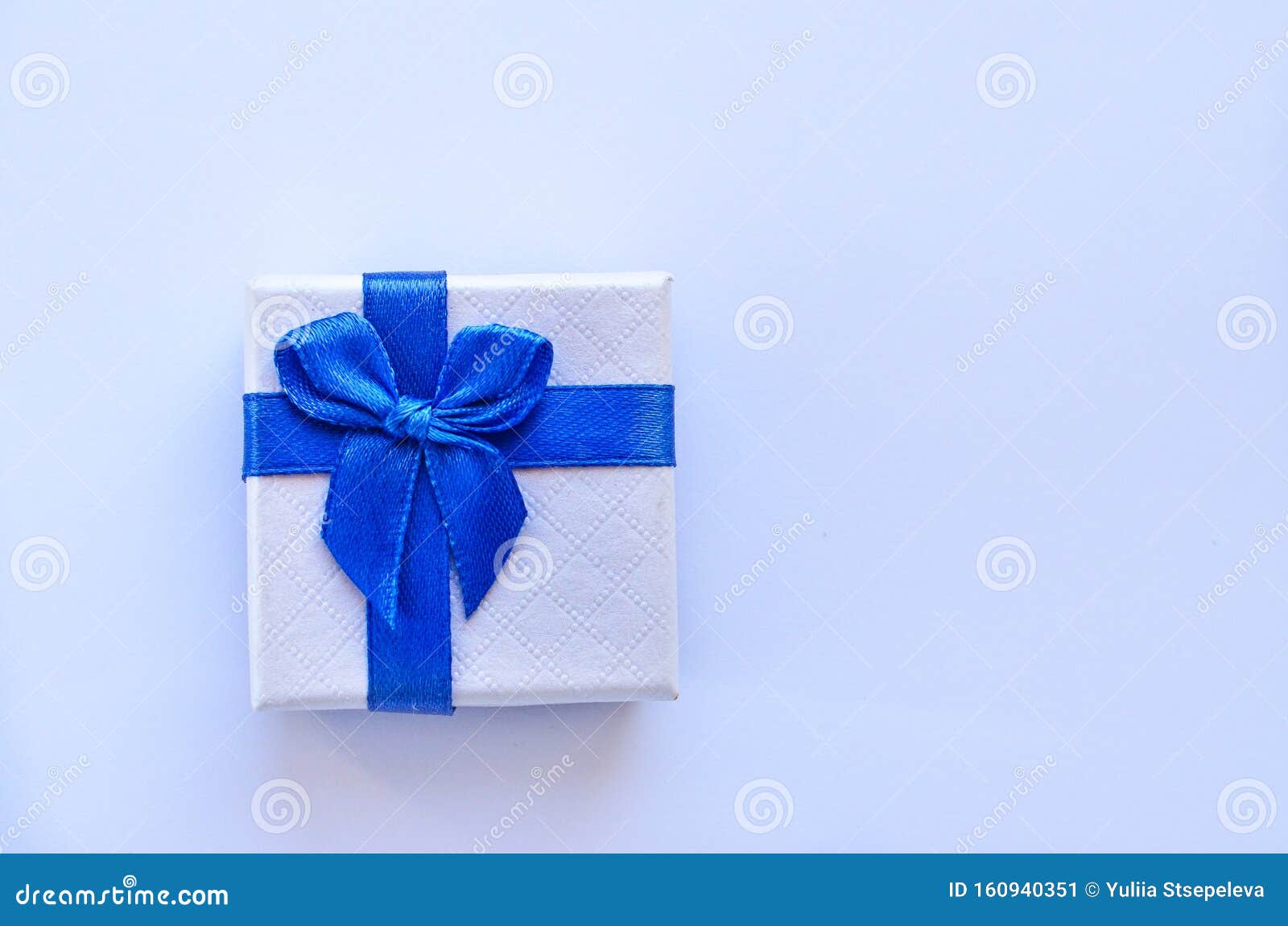 White Gift Box with a Blue Ribbon on a White Background Stock Image