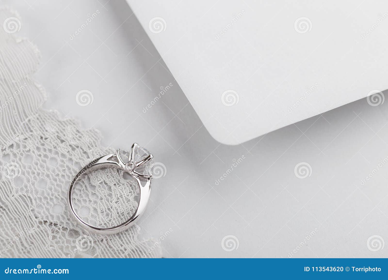 White Gold Wedding Ring with Diamonds on Gray Envelope with Copy Stock