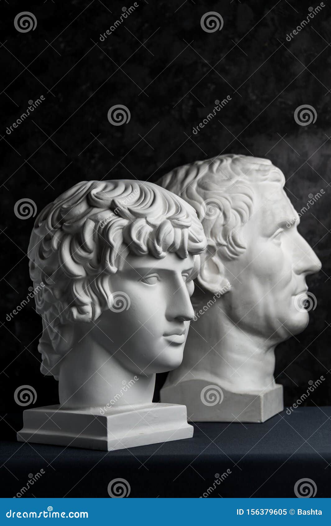 gypsum copy of ancient statue augustus and antinous head on dark textured background. plaster sculpture mans face.