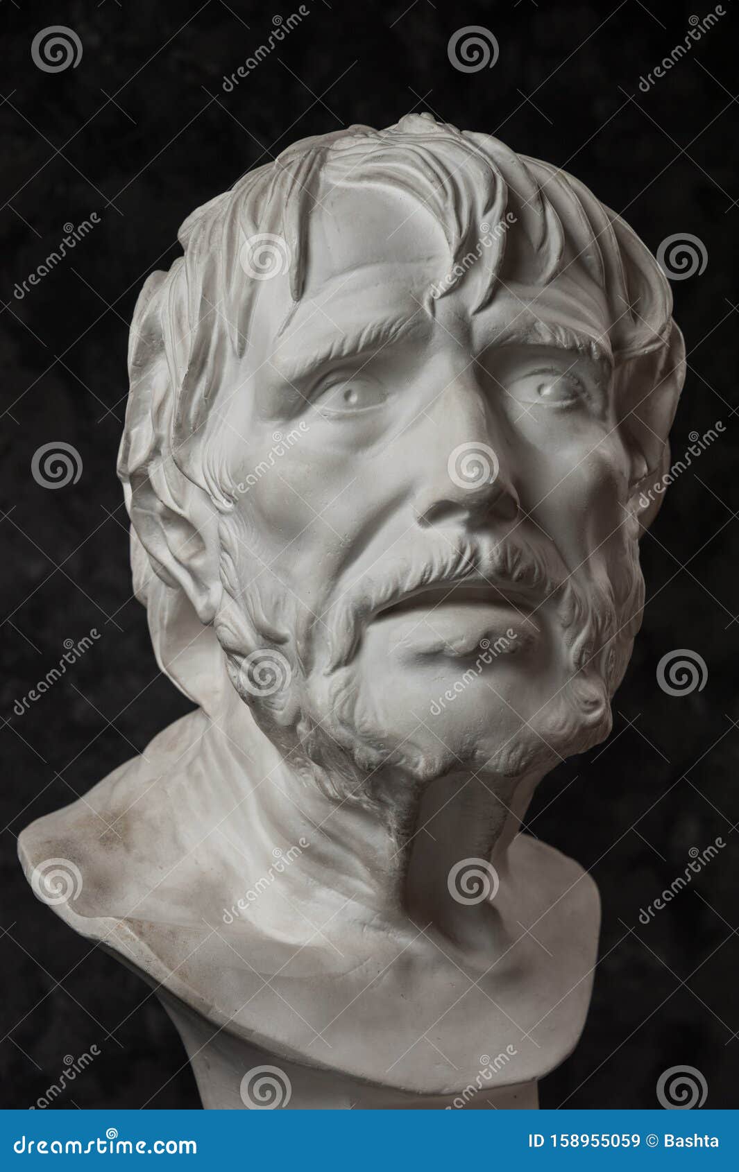 gypsum copy of ancient statue seneca head on dark textured background. plaster sculpture man face.