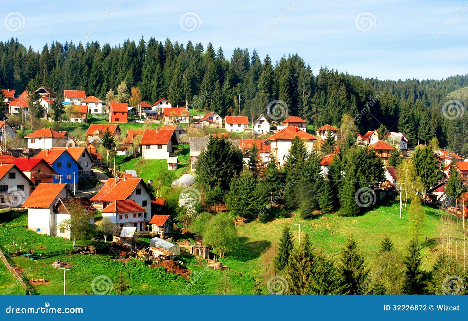 white houses with red-tiled roof by woods