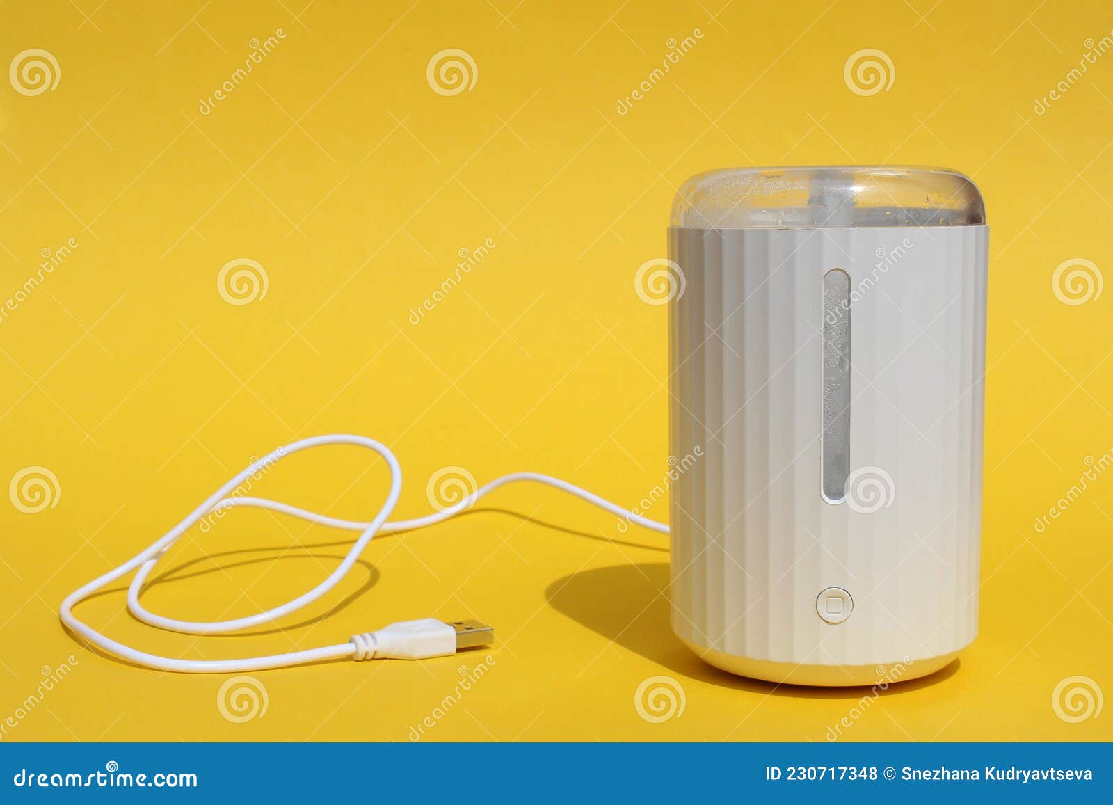 a white humidifier stands on a yellow background.
