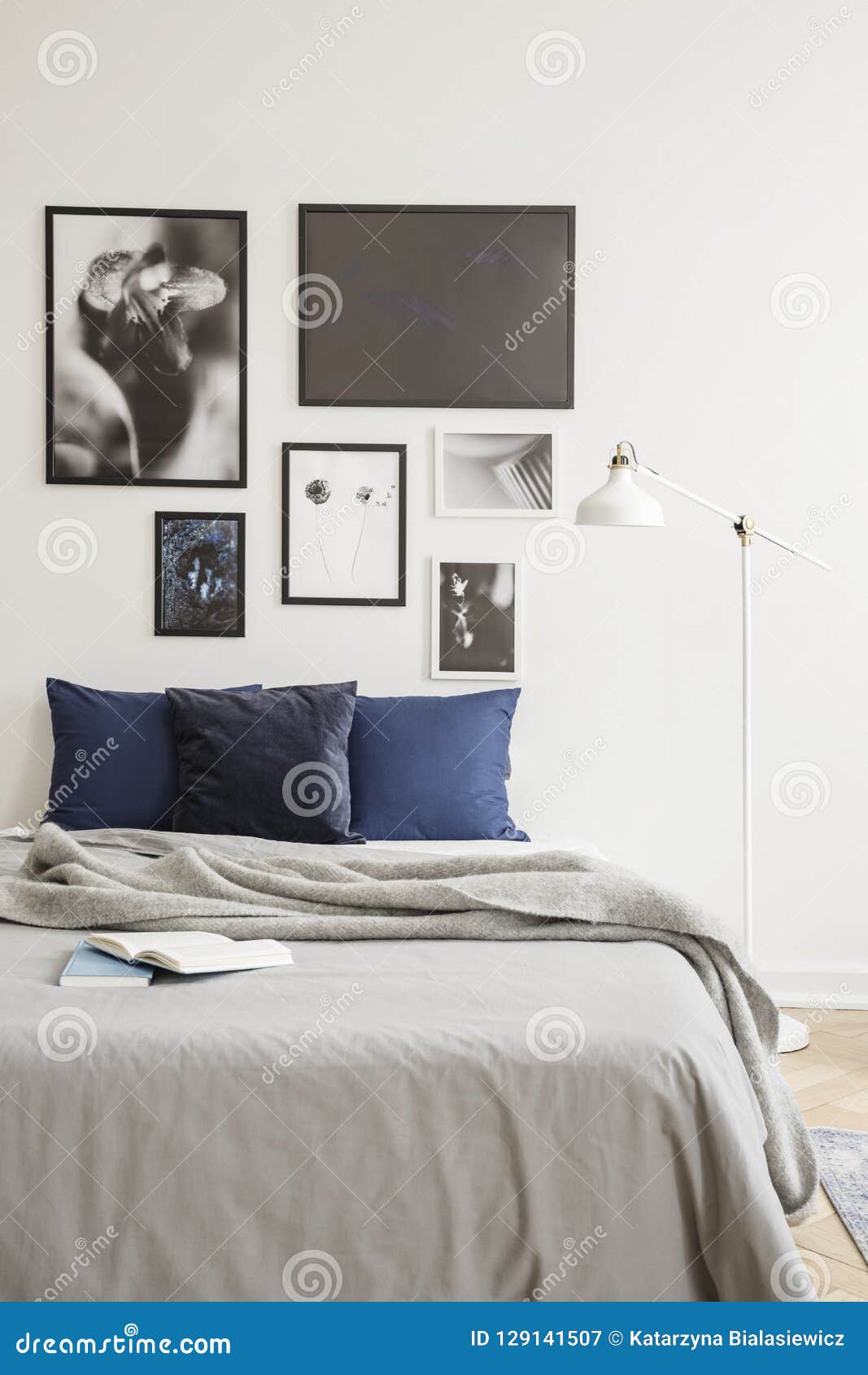 White Industrial Style Floor Lamp By A Cozy Bed With Dark Blue