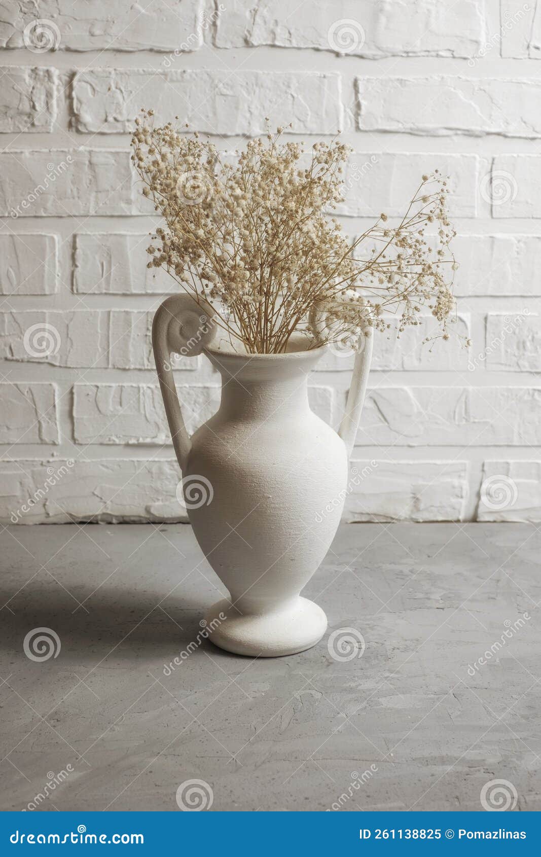 White Interior Vase with Dried Flowers Against Brick Wall Stock Image