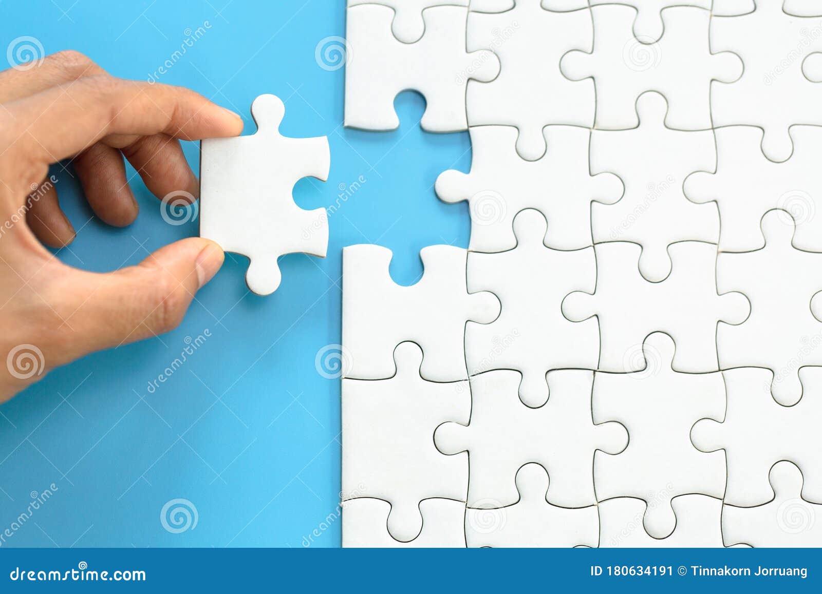 white jigsaw in the hands, the correct solution. teamwork, solving and completing the task. last piece of jigsaw puzzle.