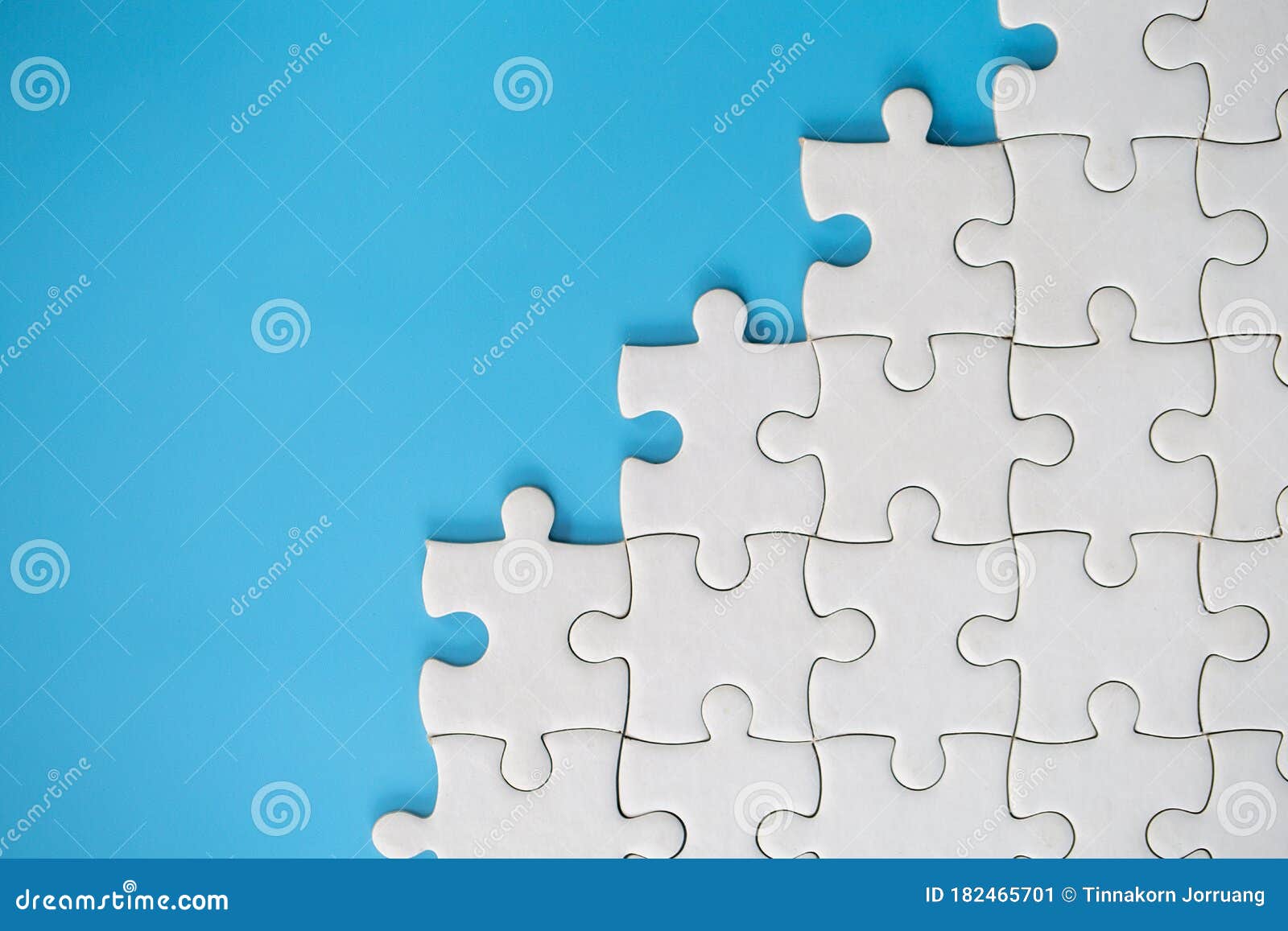 white jigsaw puzzle pieces on a blue background. problem solving . texture photo with copy space for text