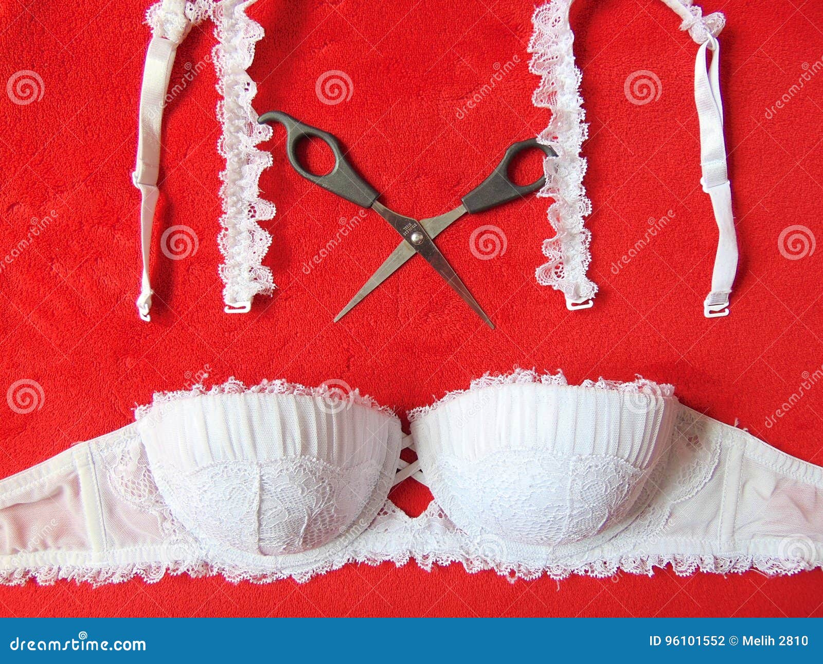 White Lace Strapless Bra with Scissors Cutting the Straps Stock Photo
