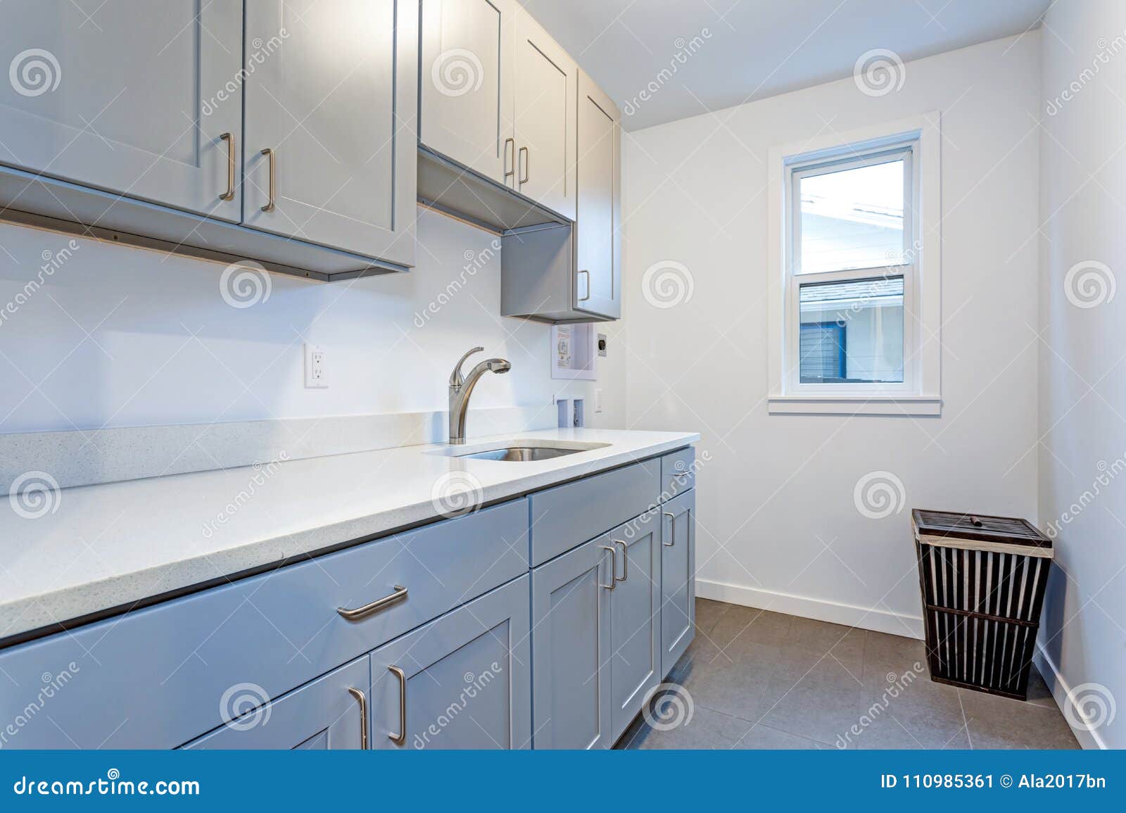 White Laundry Room With Pale Gray Shaker Cabinets Stock Image