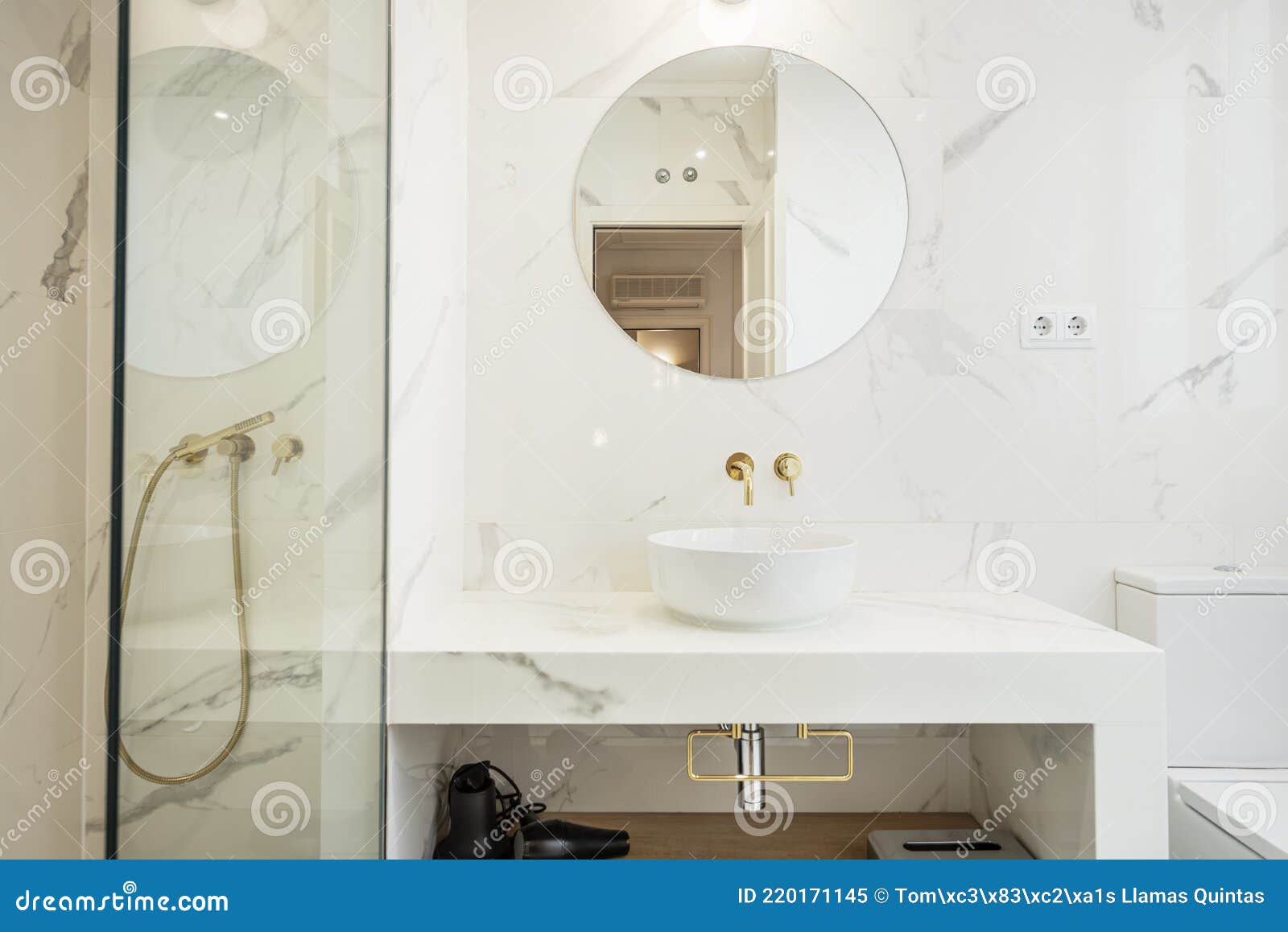 White Marble Bathroom with Round Mirror, Gold Faucets and Shower Stock