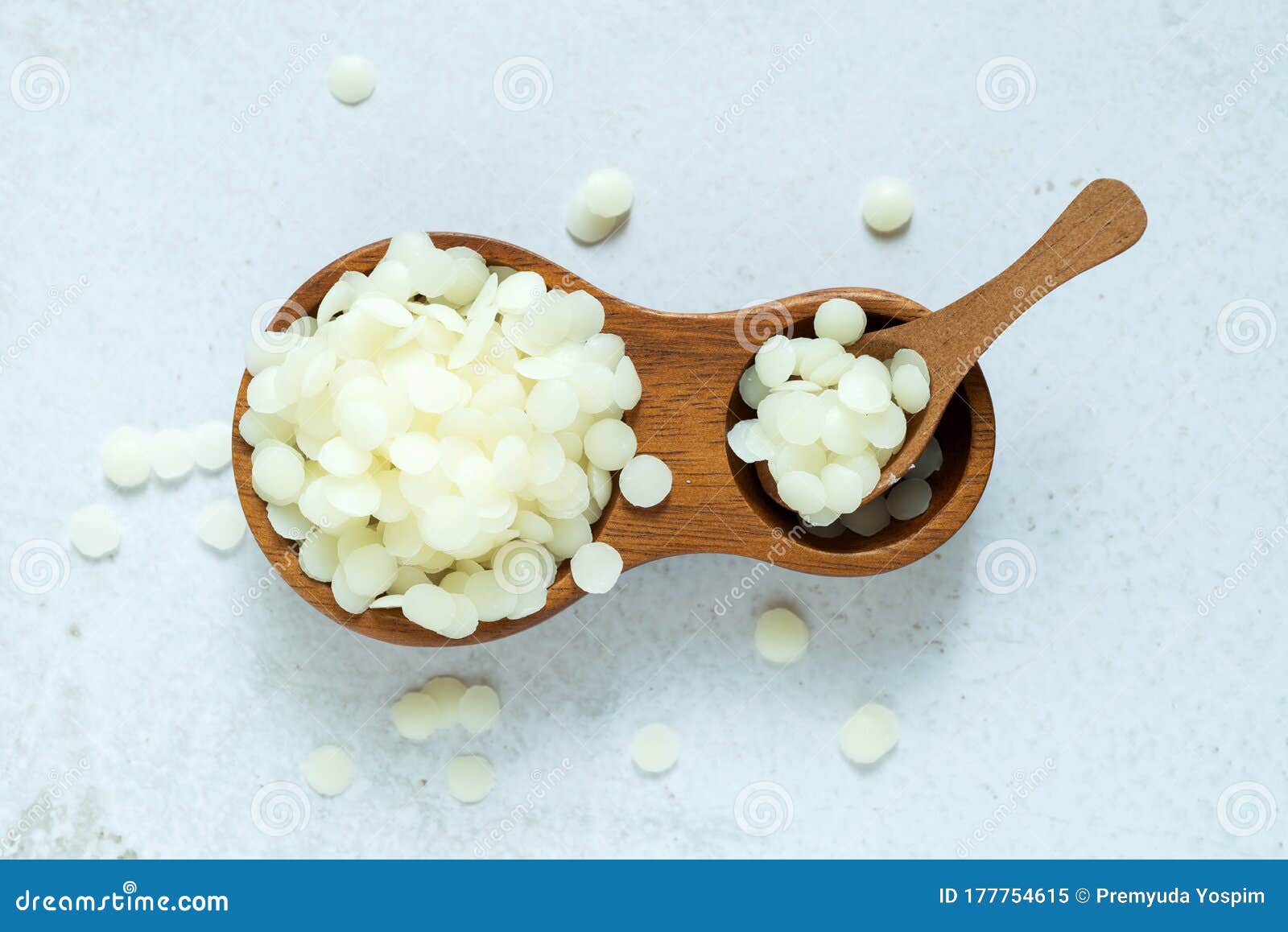 yellow and white cosmetic beeswax pellets in white ceramic bowl for  homemade natural beauty and D.I.Y. project. Stock Photo