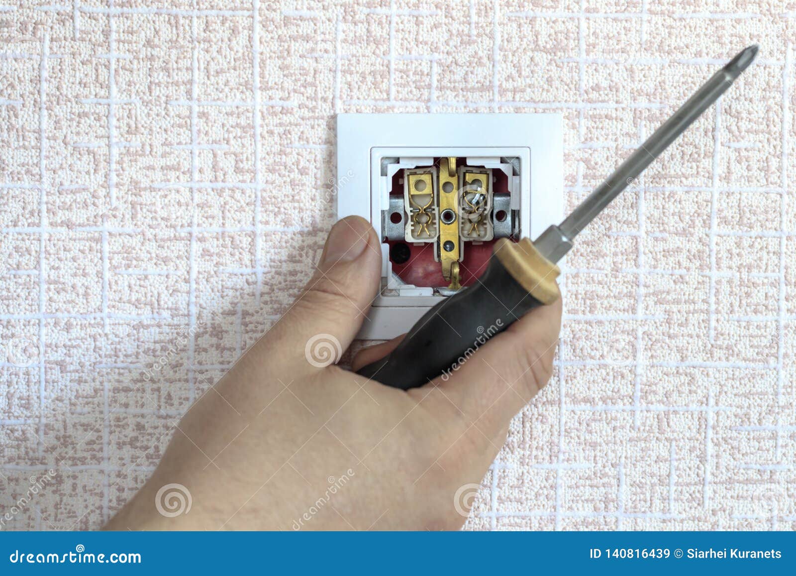 . White Outlet. the Wizard with a Screwdriver Sets it in Place Stock