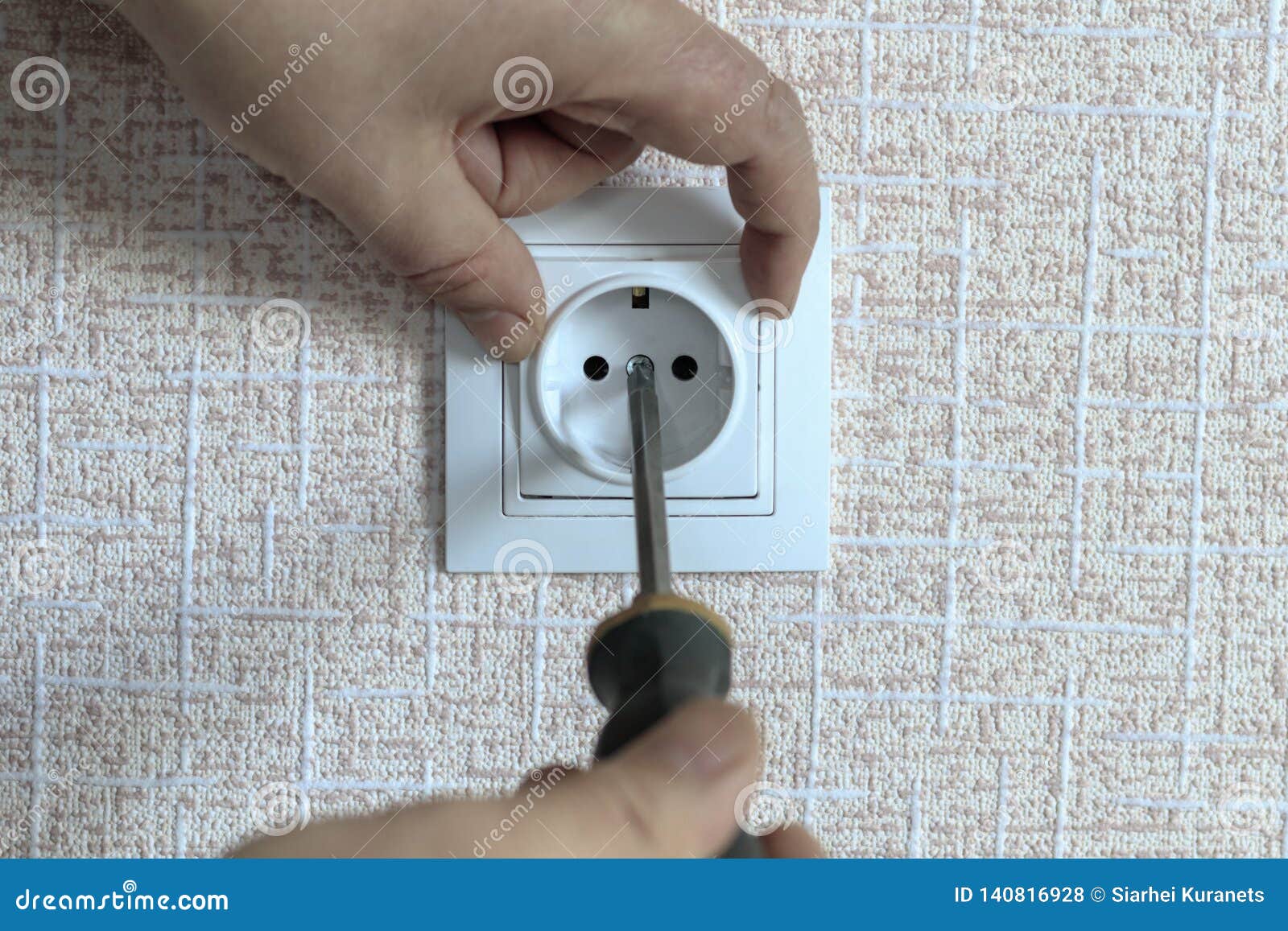 . White Outlet. the Wizard with a Screwdriver Sets it in Place Stock