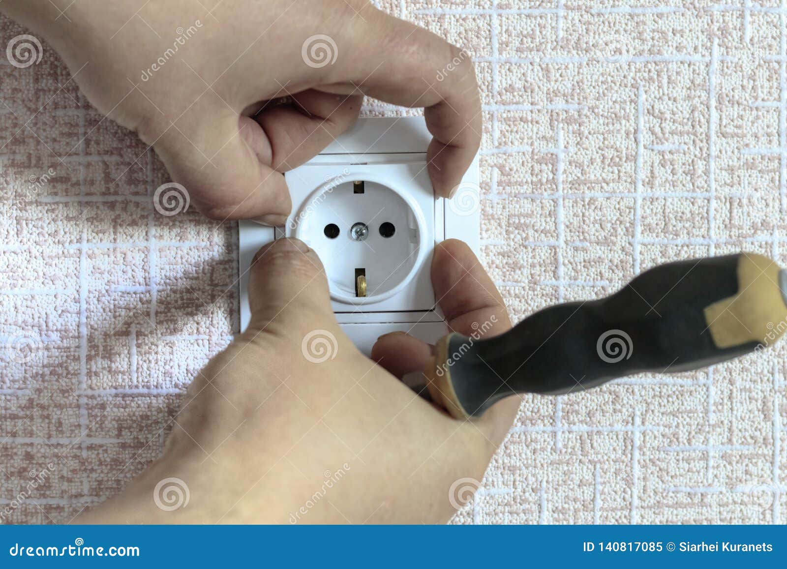 . White Outlet. the Wizard with a Screwdriver Sets it in Place Stock