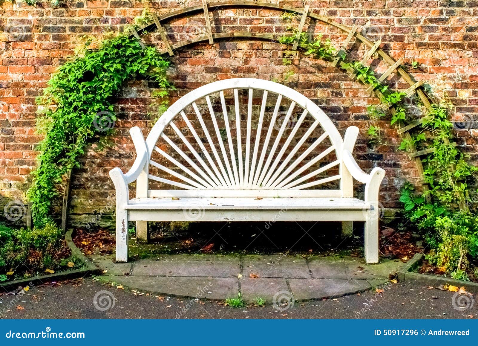 White Park Bench Seat Against Old Brick Wall Stock Photo