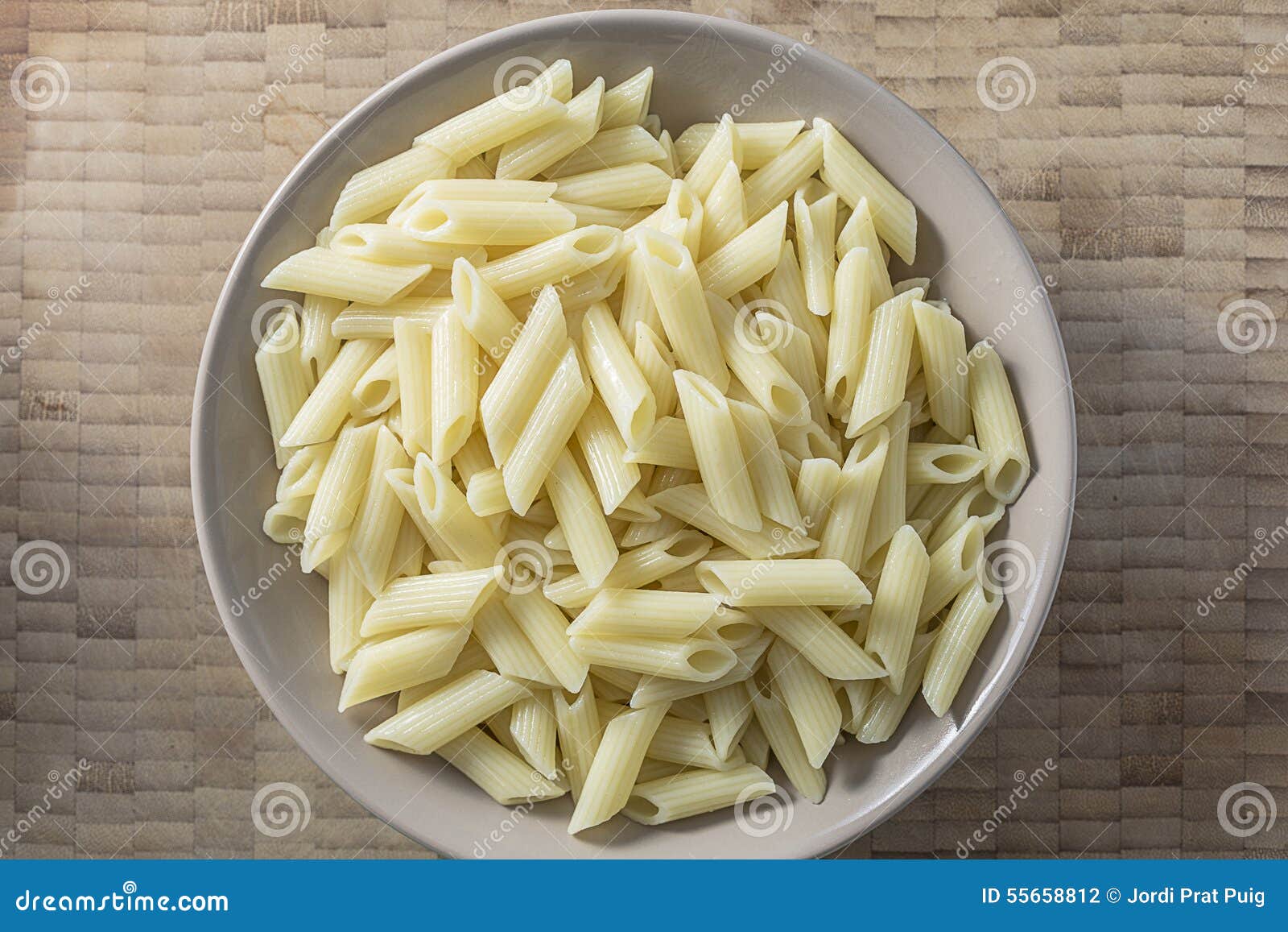 white pasta on a brown bowl wooden background top view