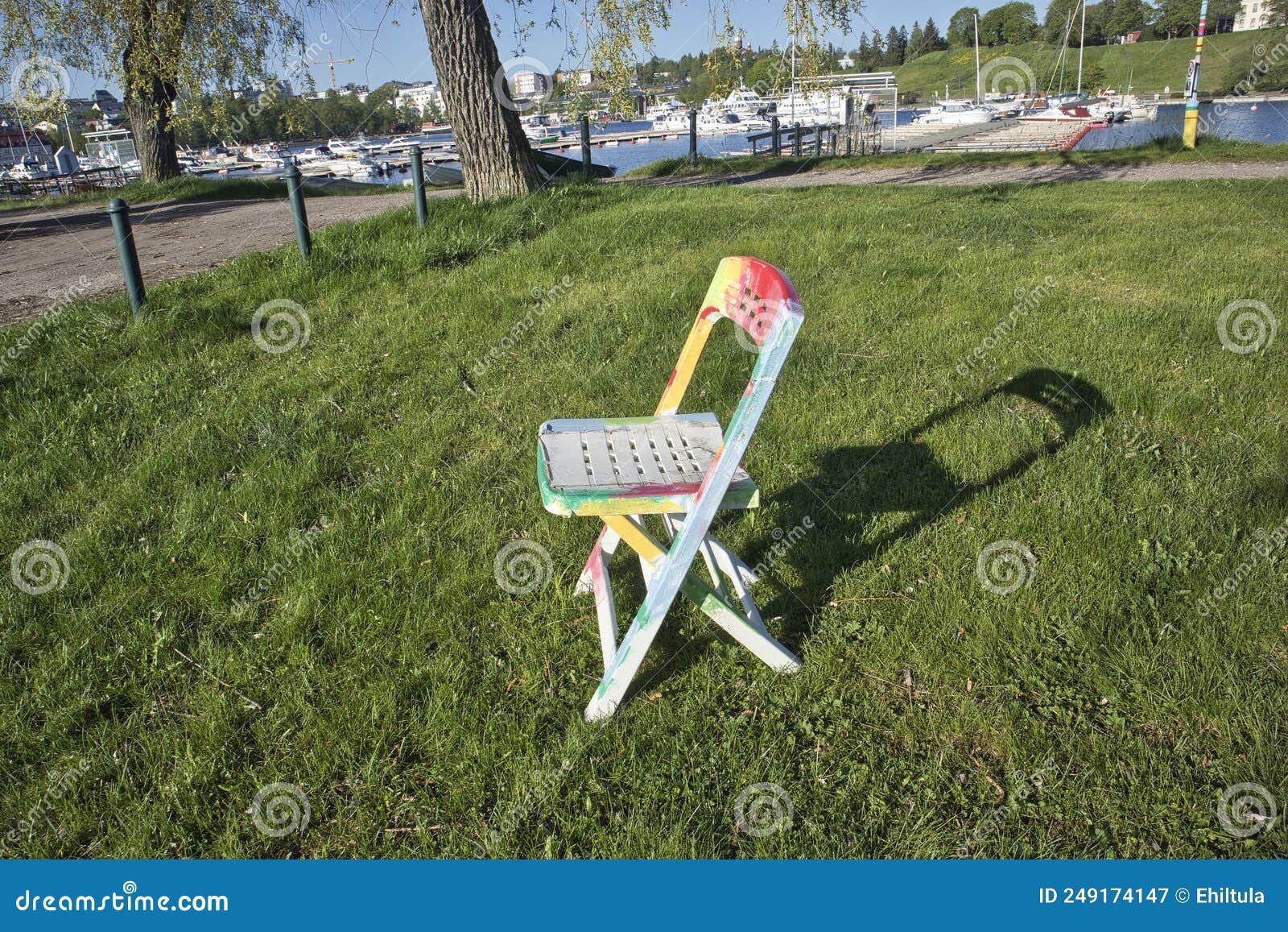 White Plastic Chair with Multicolored Paint Spots Outdoors Stock Image