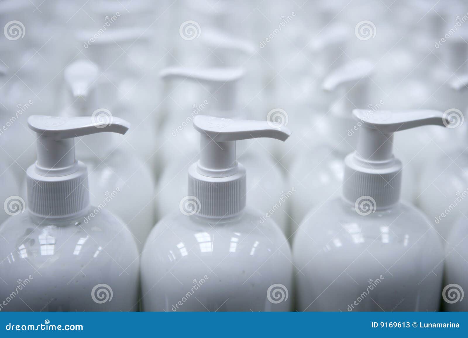 white plastic soap bottles in rows assembly line
