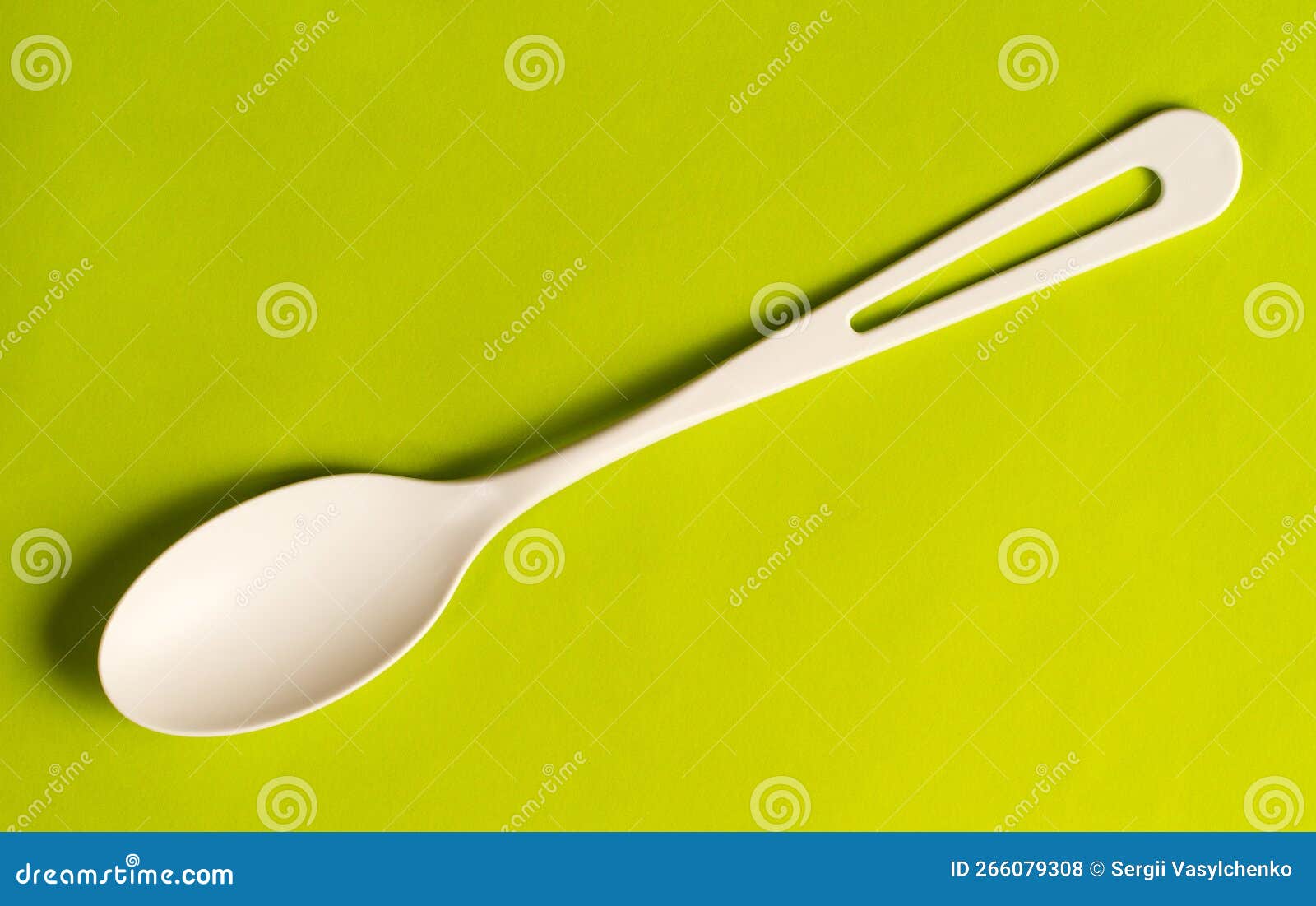A White Plastic Spoon on a Green Background. Stock Photo Image of