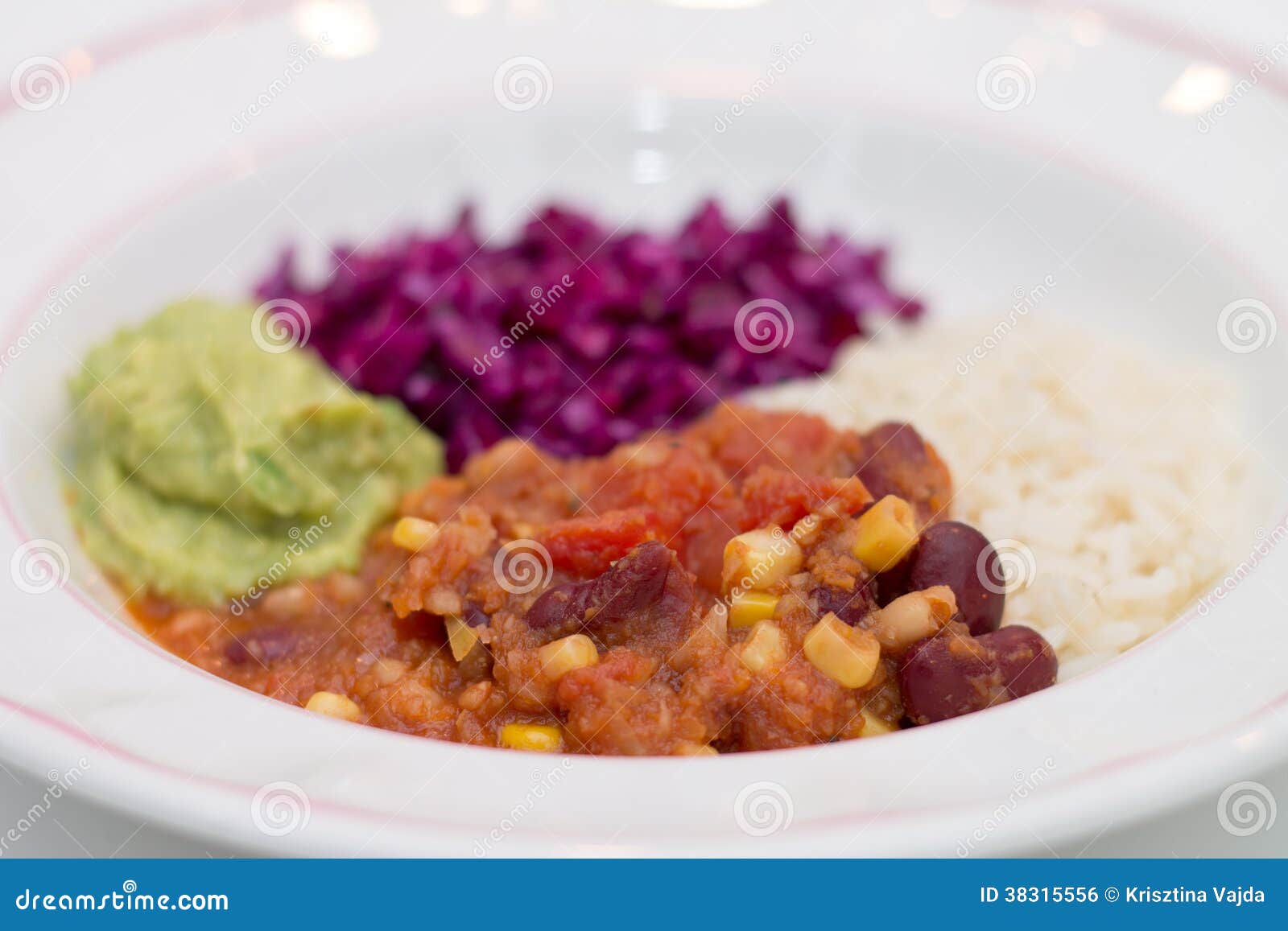 white plate of chili sin carne with red cabbage, guacamole and r