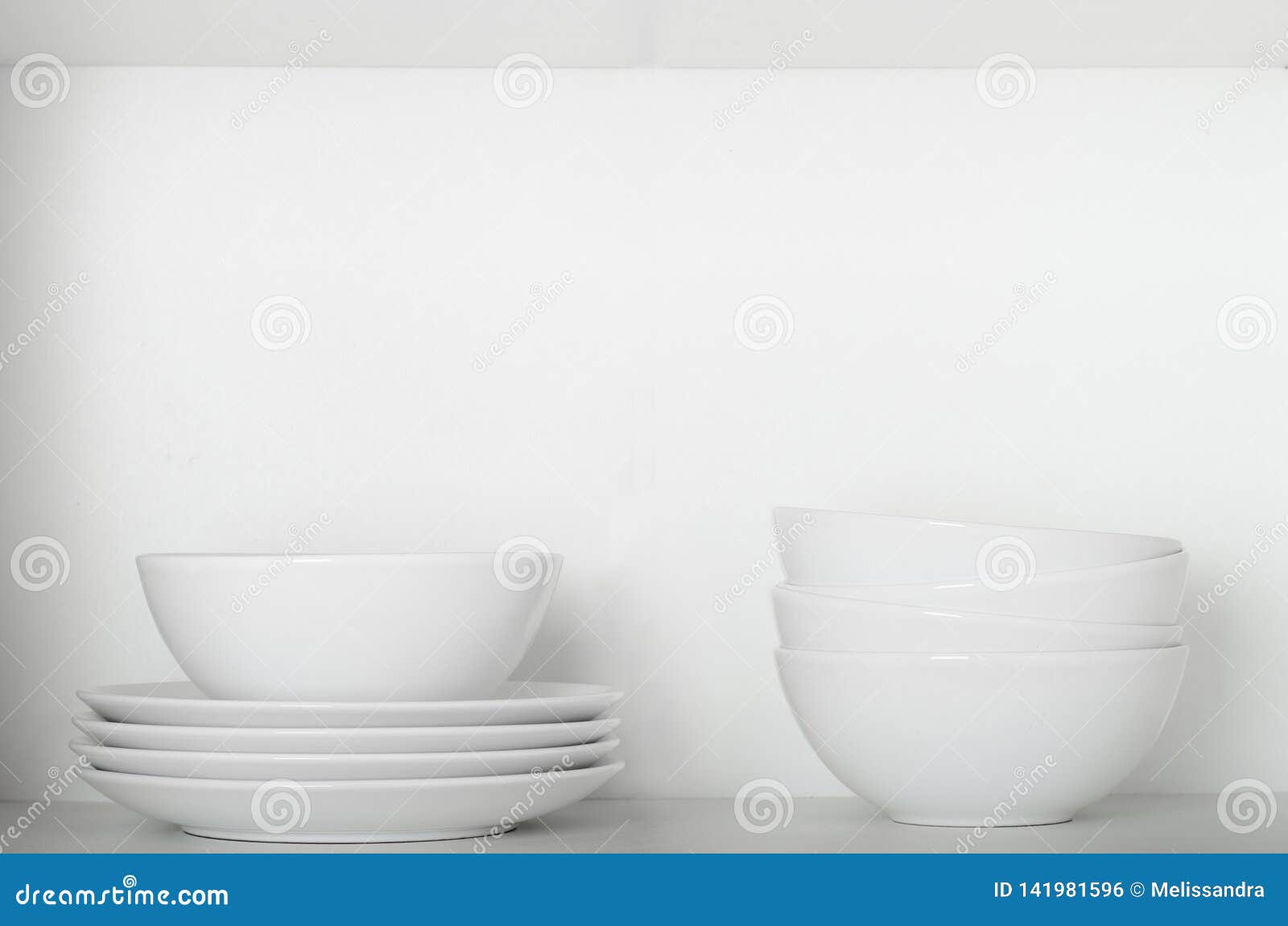 White Plates and Bowls on a Shelf in the Cupboard. Kitchenware, Clean
