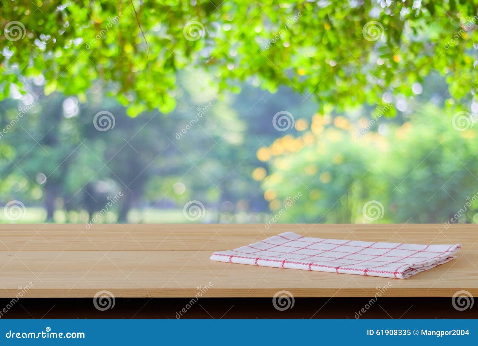 White And Red Tartan Cloth On Wood Table Over Blur Garden 
