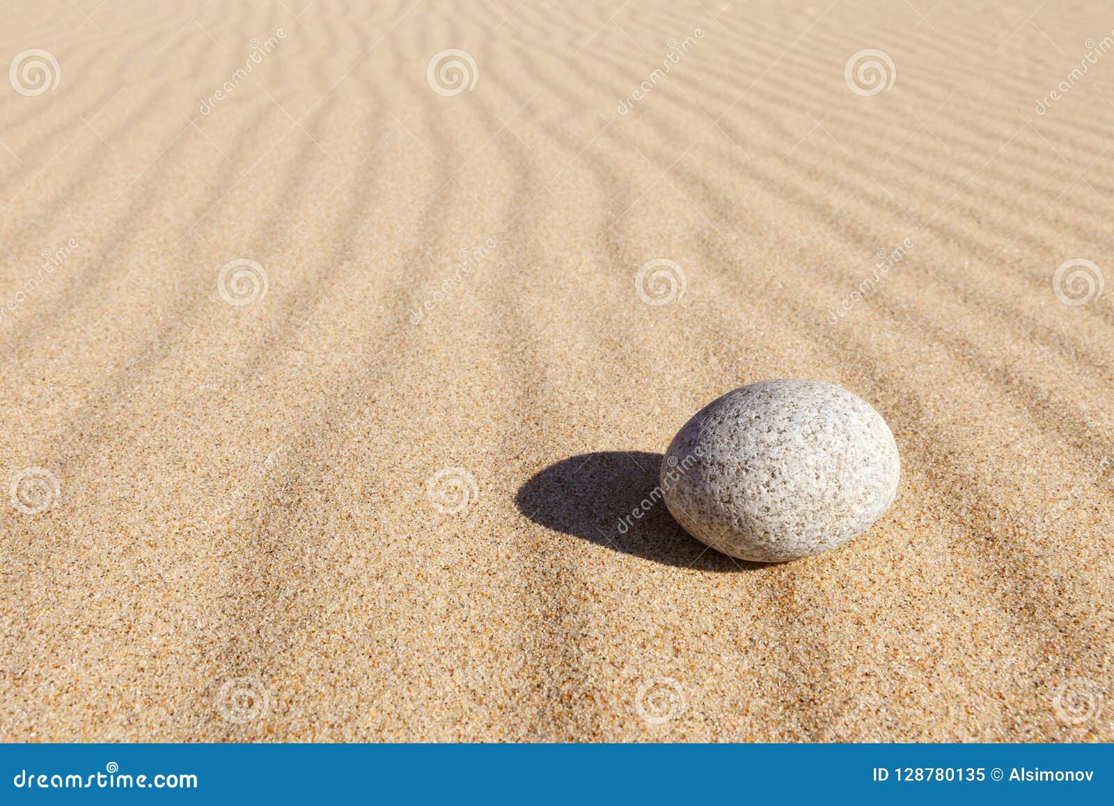 white round stone lying on clean sand. concept of balance, harmony and meditation. minimalism