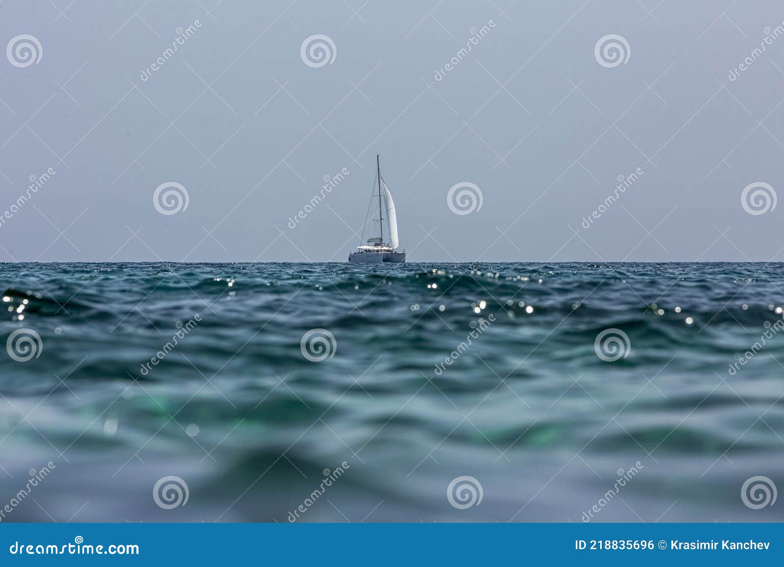 white sailing boat catamaran on ocean near beach.