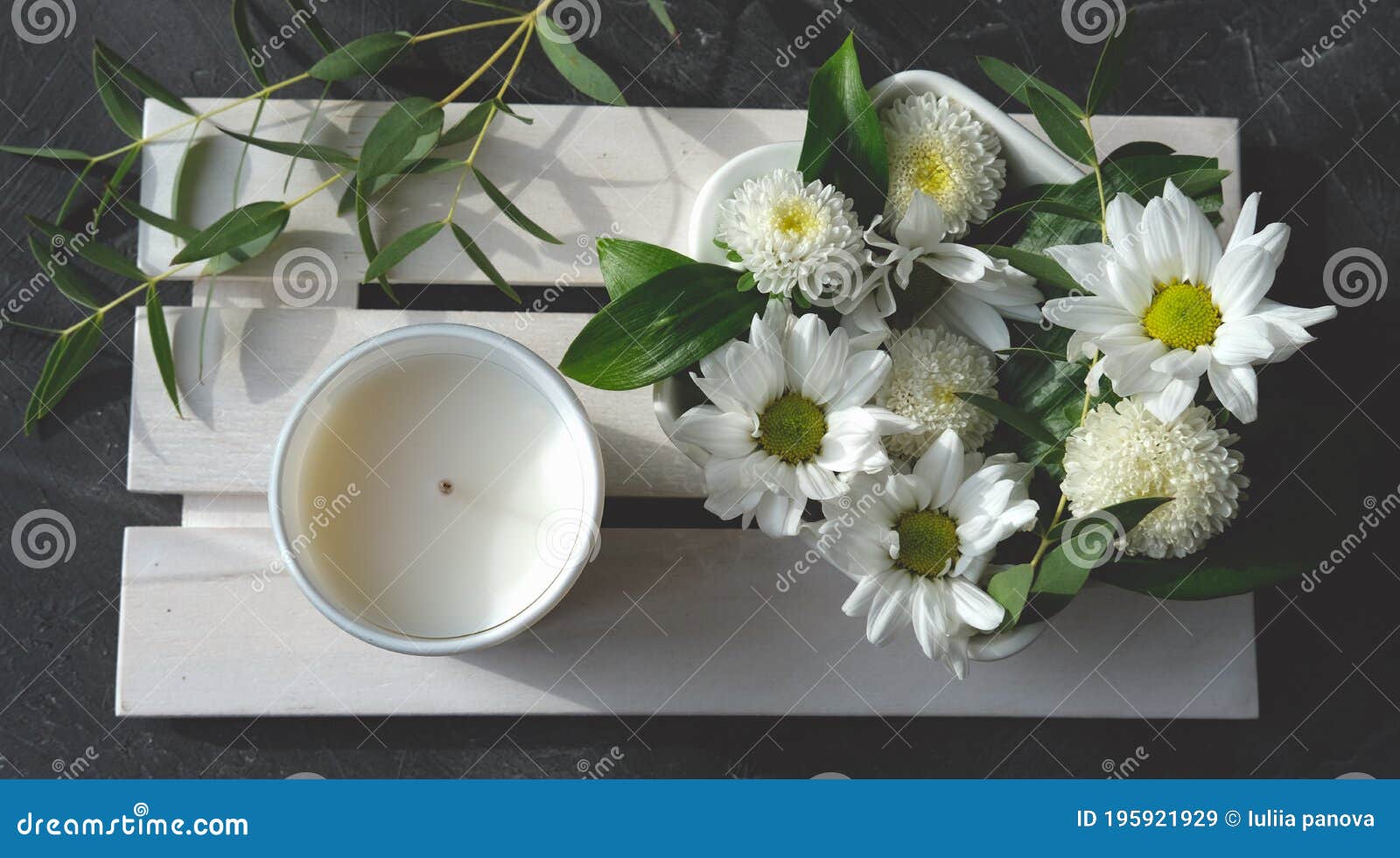 white scented candle and delicate flowers