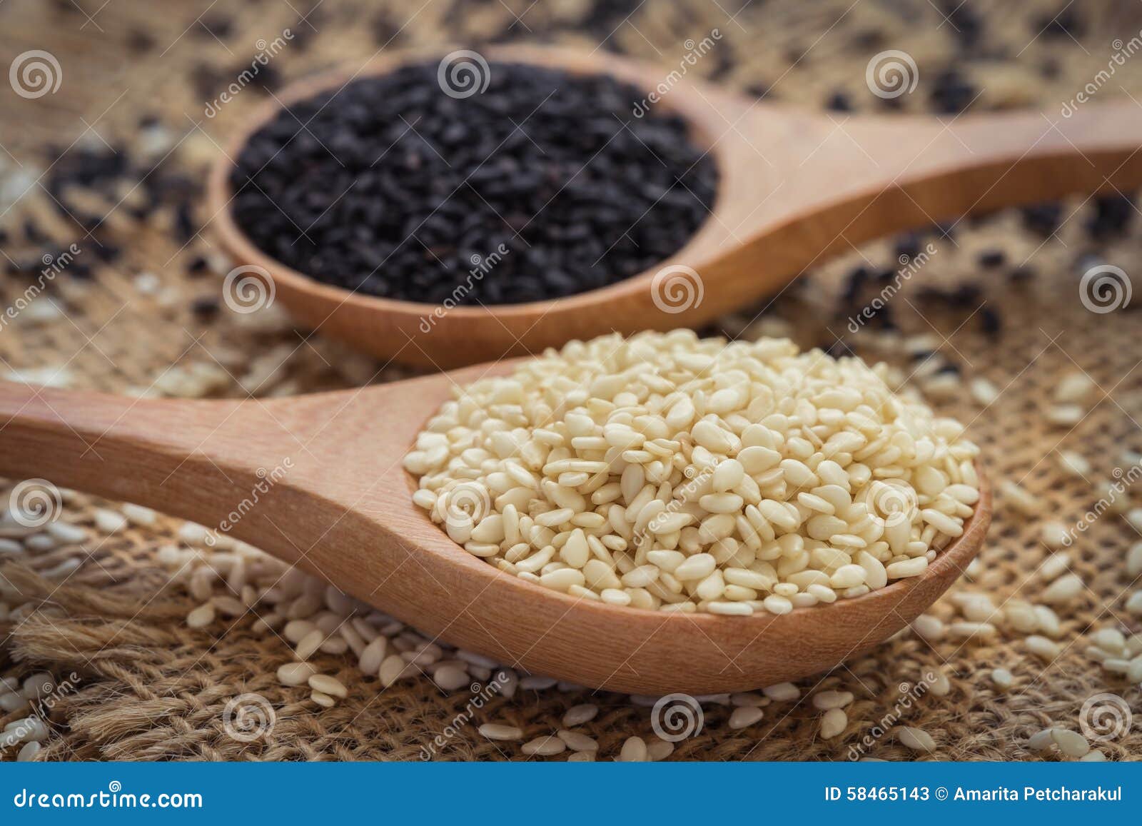 white sesame and black sesame seed on wooden spoon