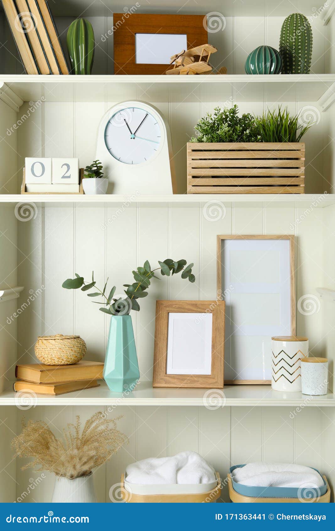 White Shelving Unit with Photo Frames and Different Decorative Elements