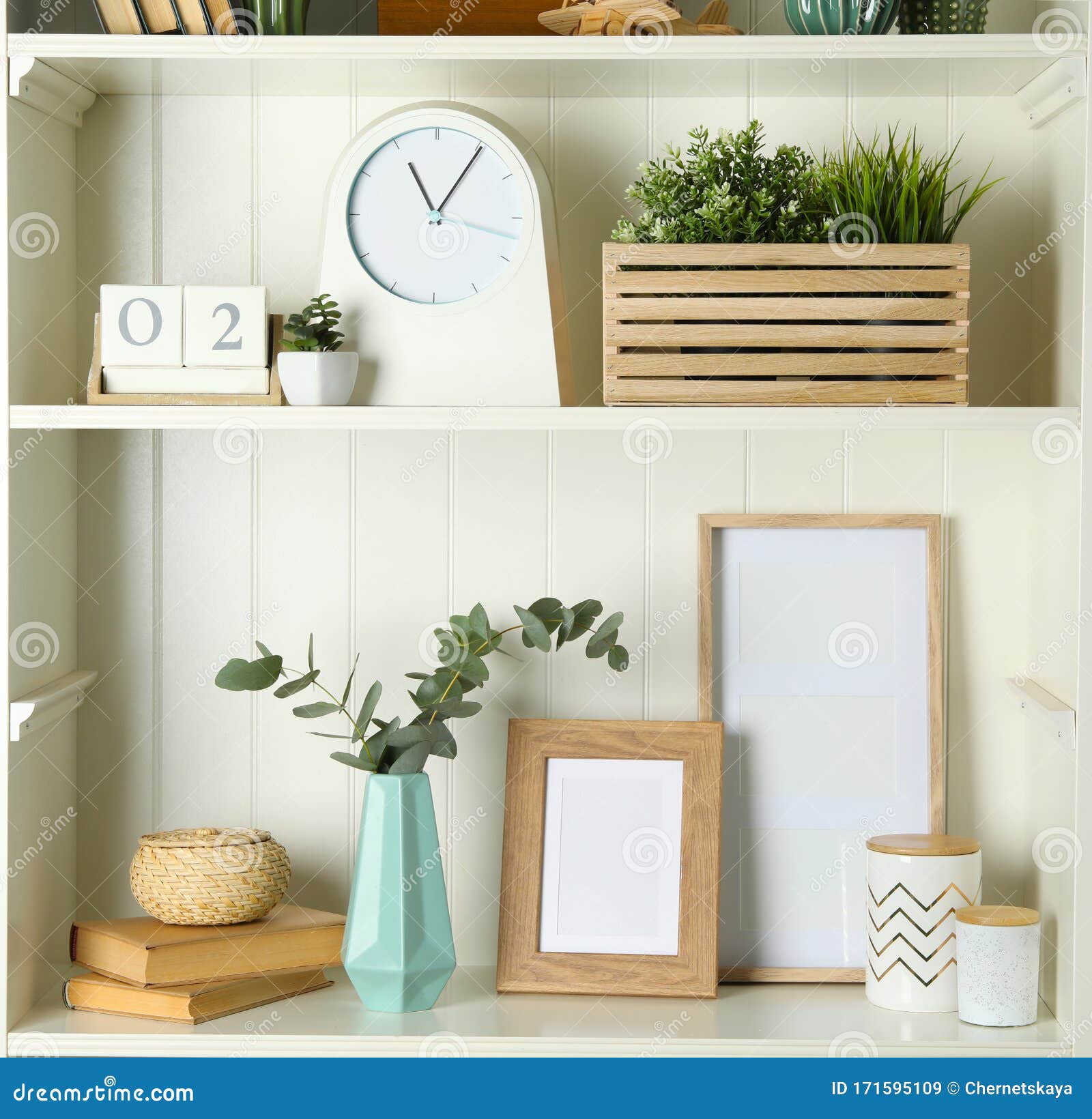 White Shelving Unit with Photo Frames and Different Decorative Elements