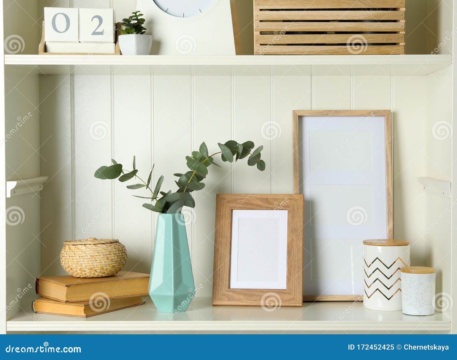 White Shelving Unit with Photo Frames and Decorative Elements Stock