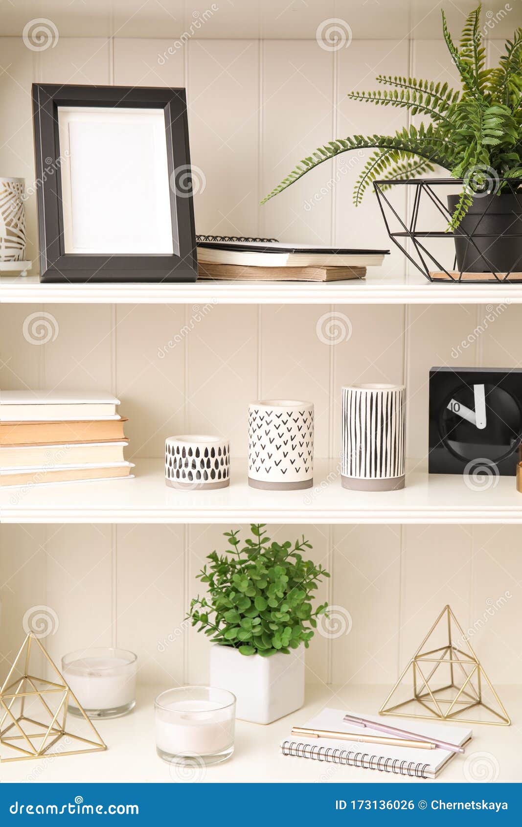 White Shelving Unit with Plants and Decorative Stuff Stock Photo