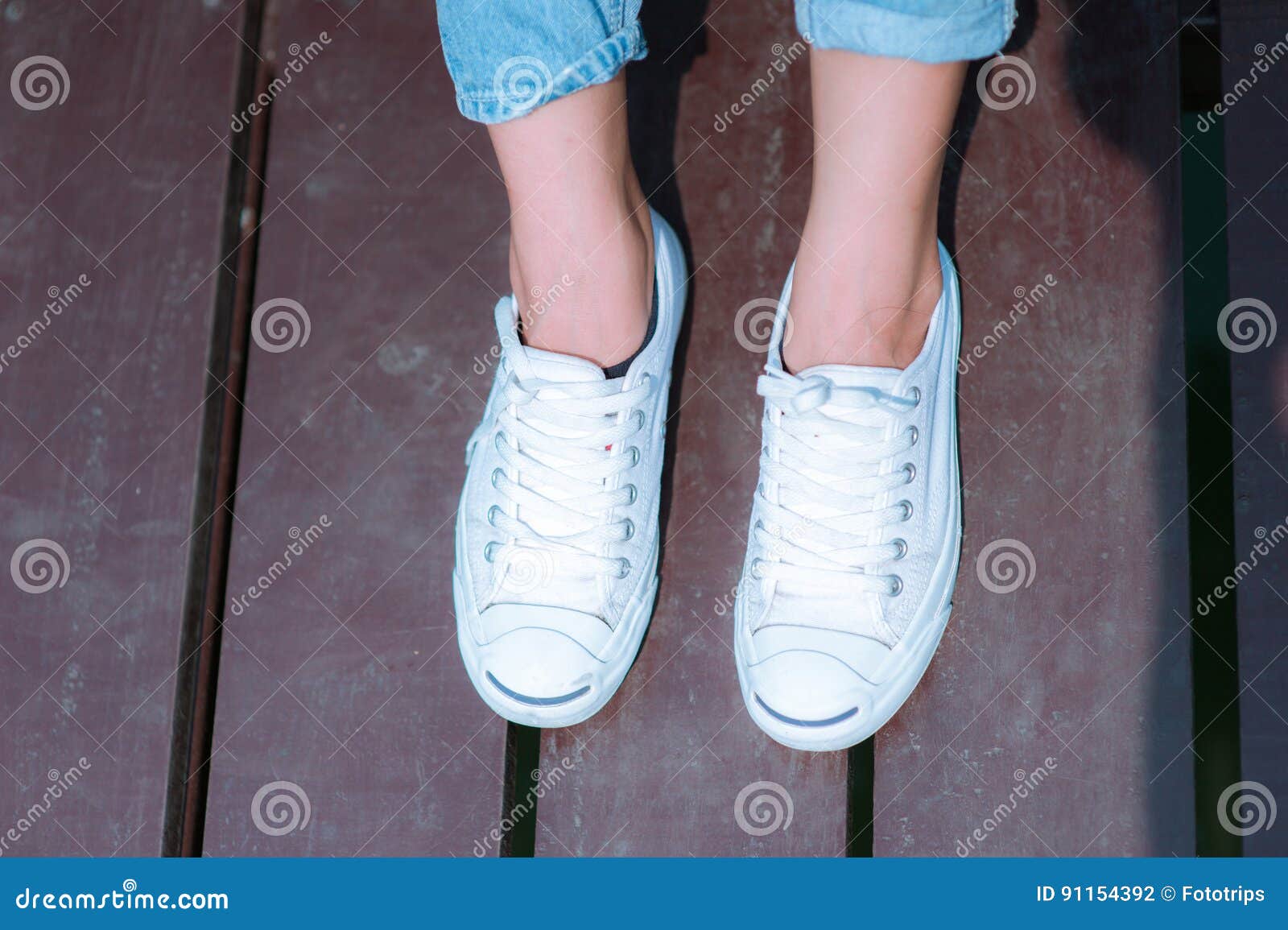 White Shoes,Fashion Woman`s Legs With Sneakers Seated On Wooden Floor ...