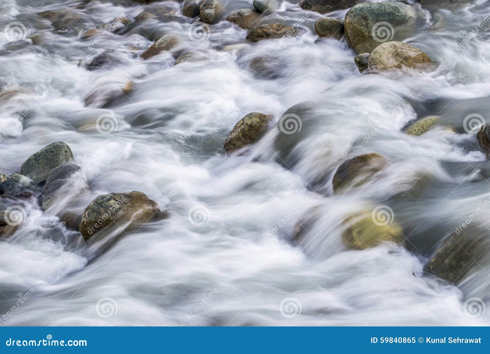 white silky water flowing downstream over the rocks and boulders